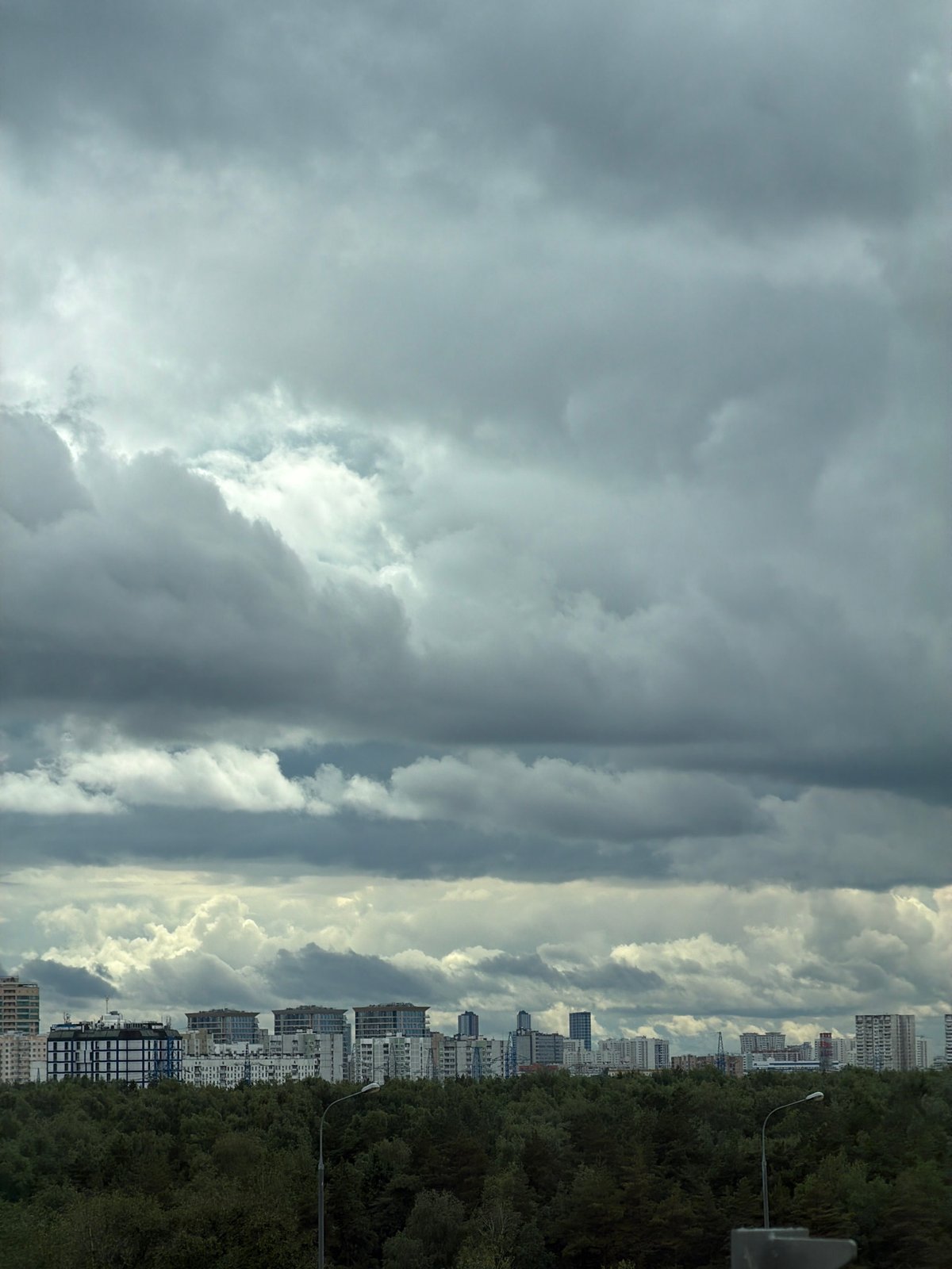 Storm clouds gathering over Moscow's tree-lined skyline