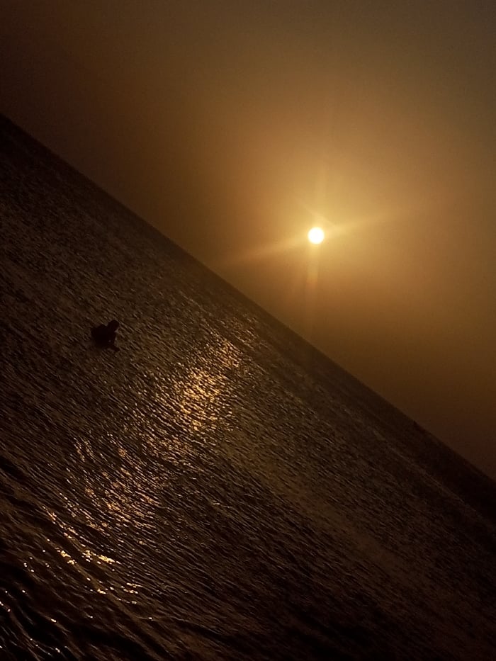 Woman photographs beach vacation moments at Venezuelan sunset