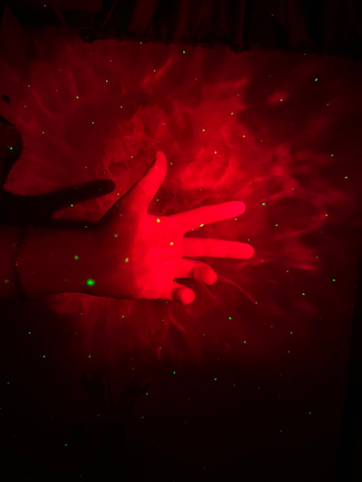 Hands play in projected nebula light at a Saint Petersburg installation