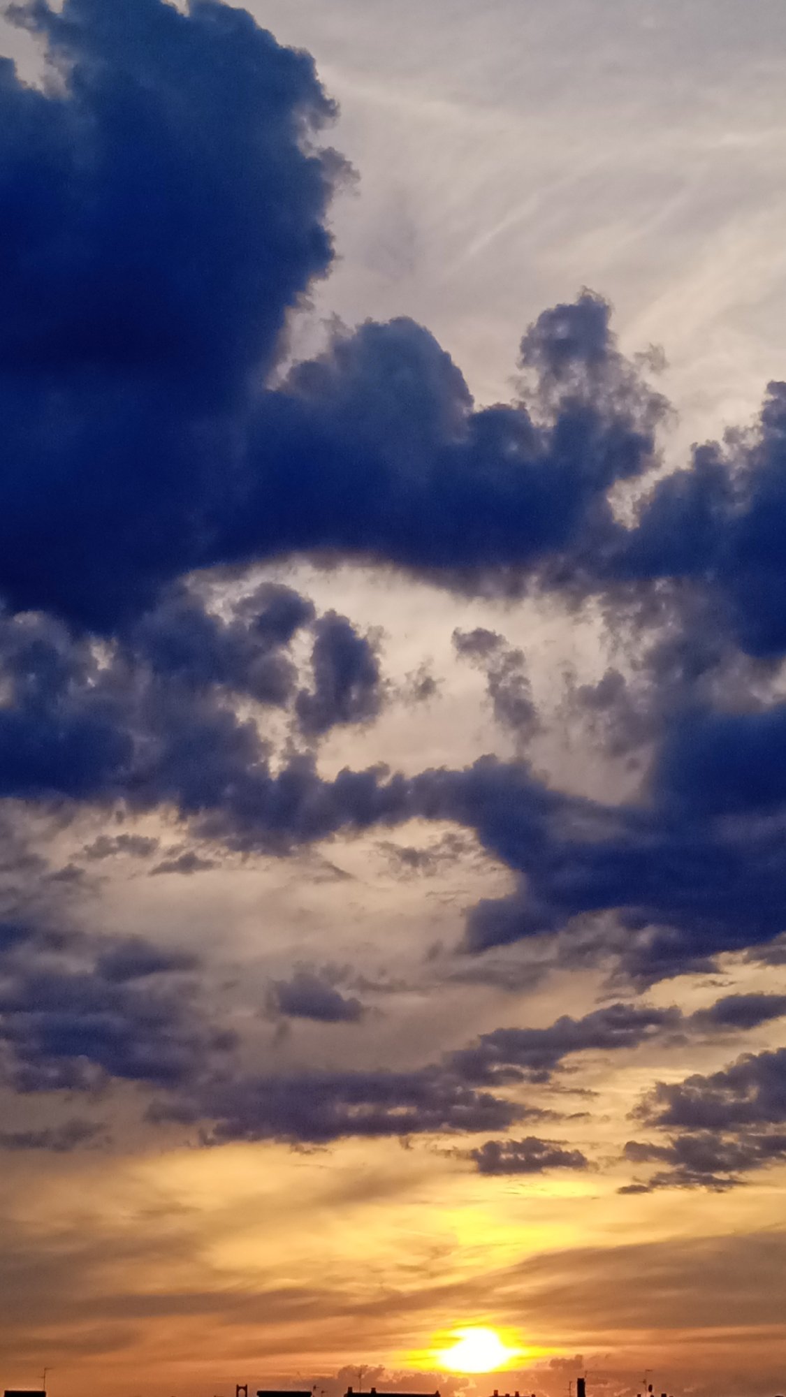 Storm clouds and a vivid sun collide at sunset