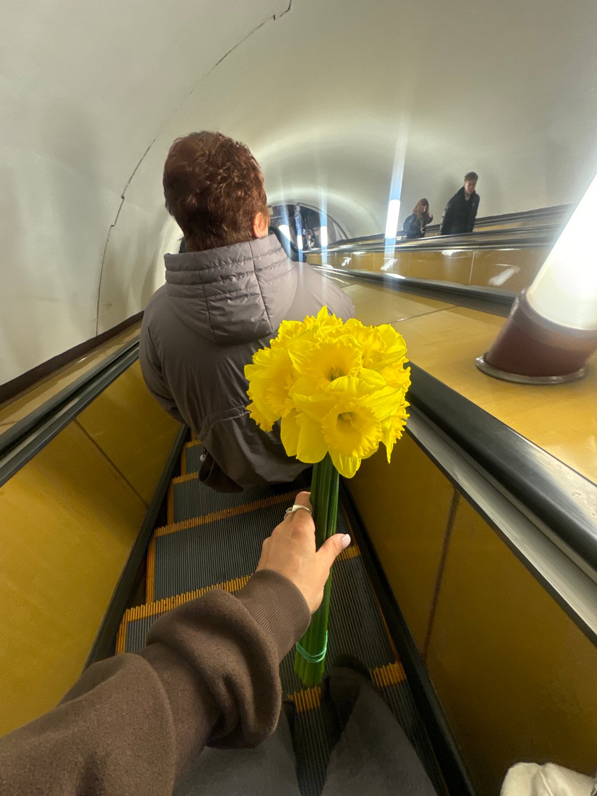 Spring flowers carried on Moscow escalator