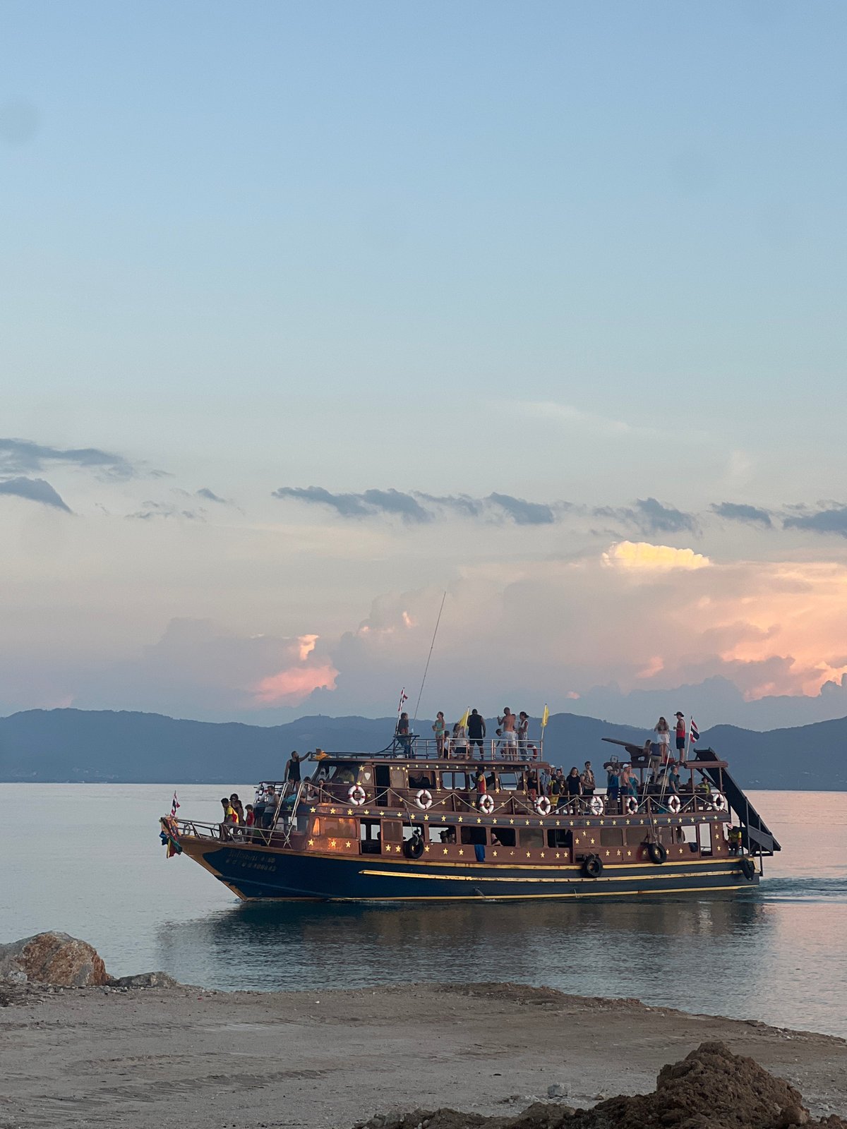 Multi-deck tour boat anchored off Ko Pha-ngan at sunset