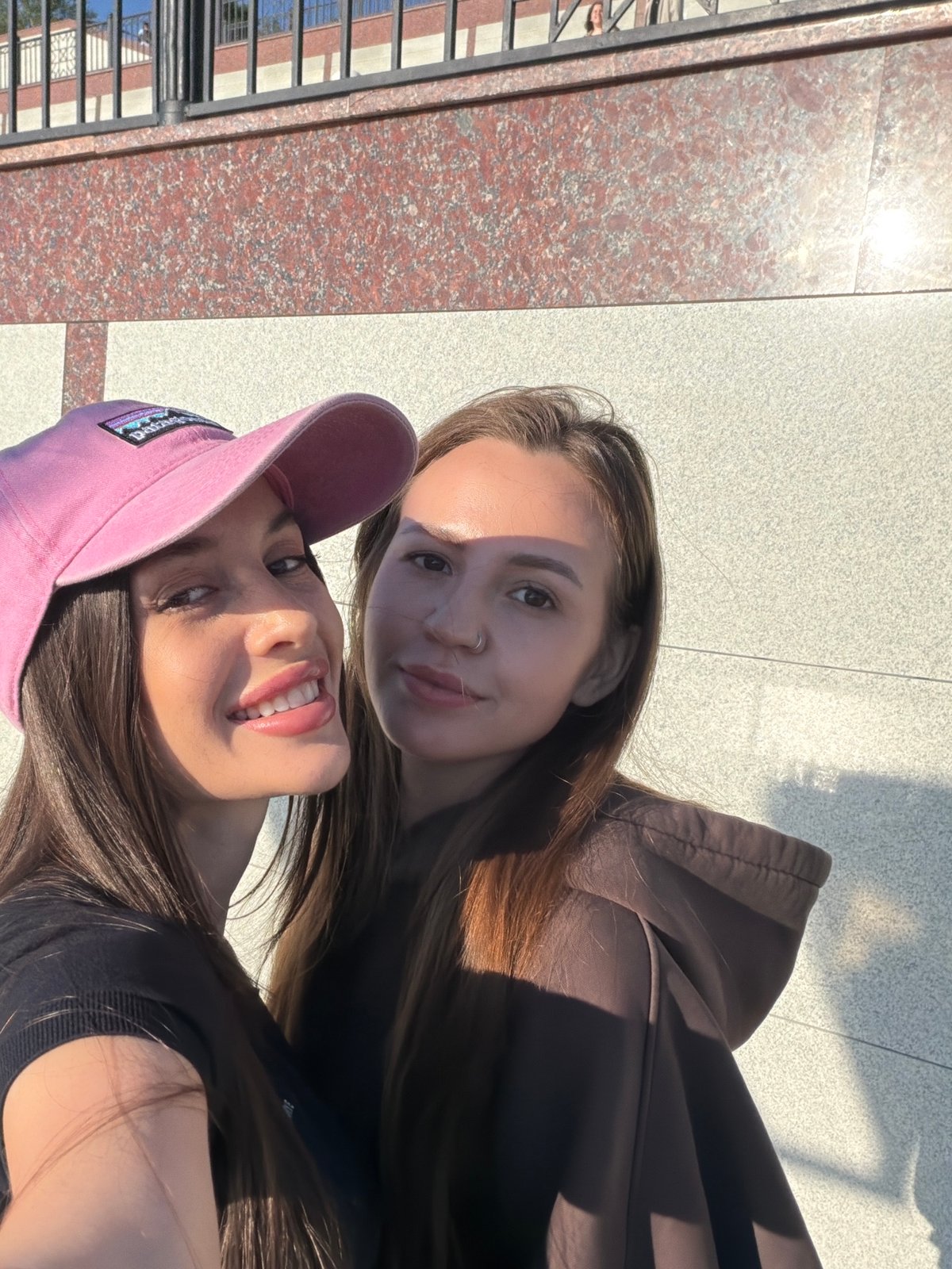 Woman documents sunny afternoon outing on Izhevsk waterfront promenade
