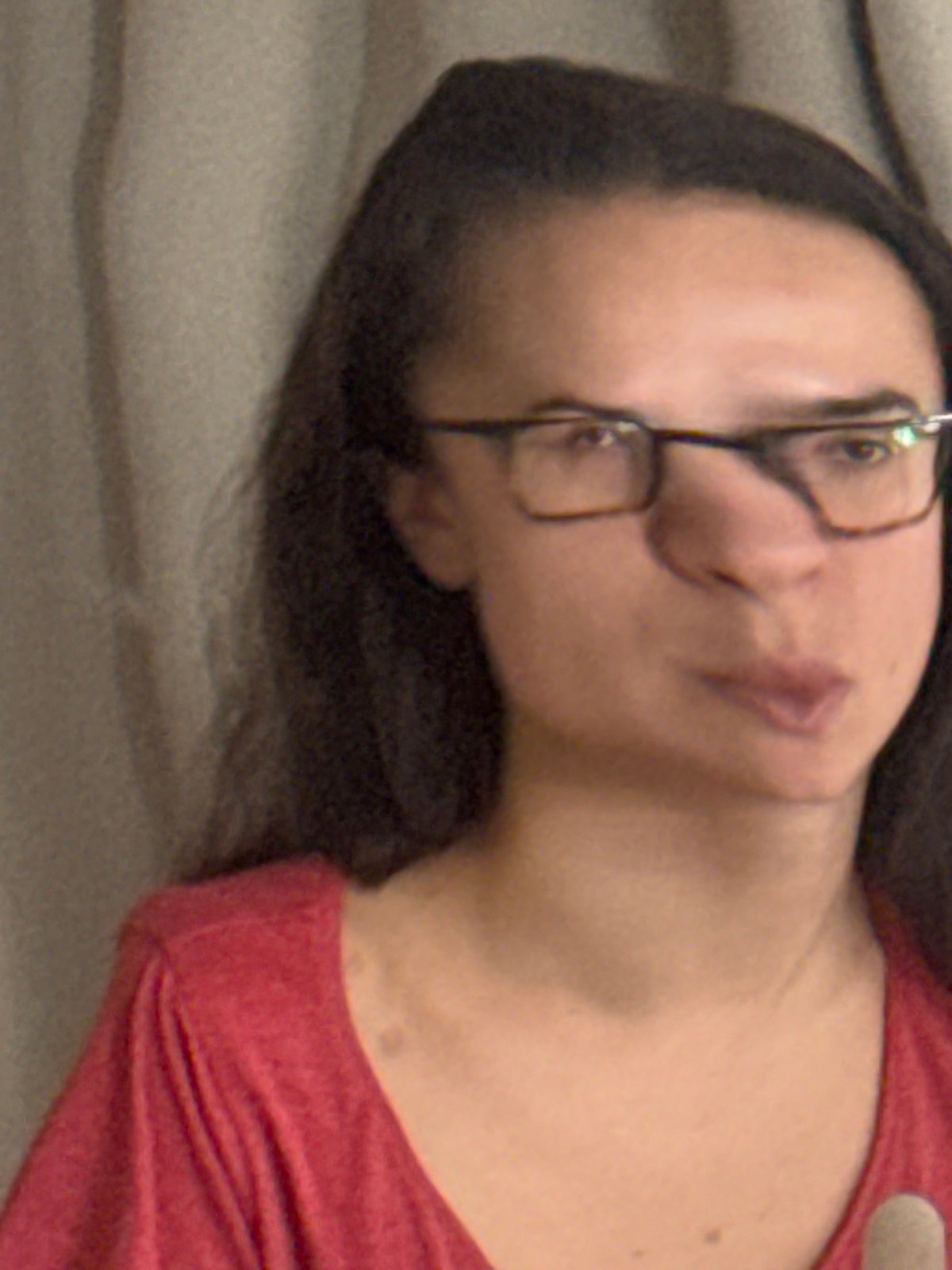 Woman in red shirt photographed during morning meal in Krasnoyarsk