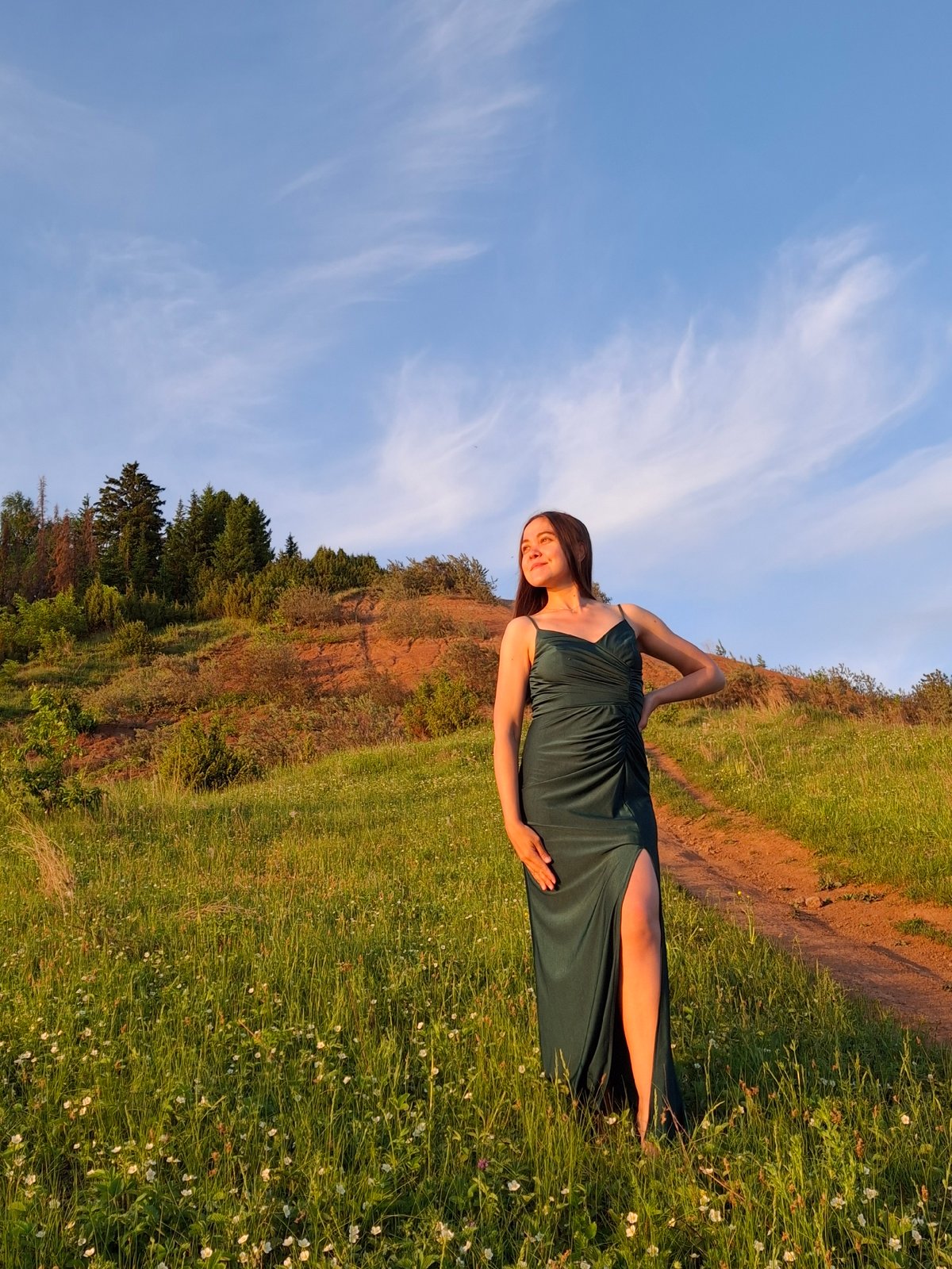 Woman in green dress photographed in Russian countryside during sunset
