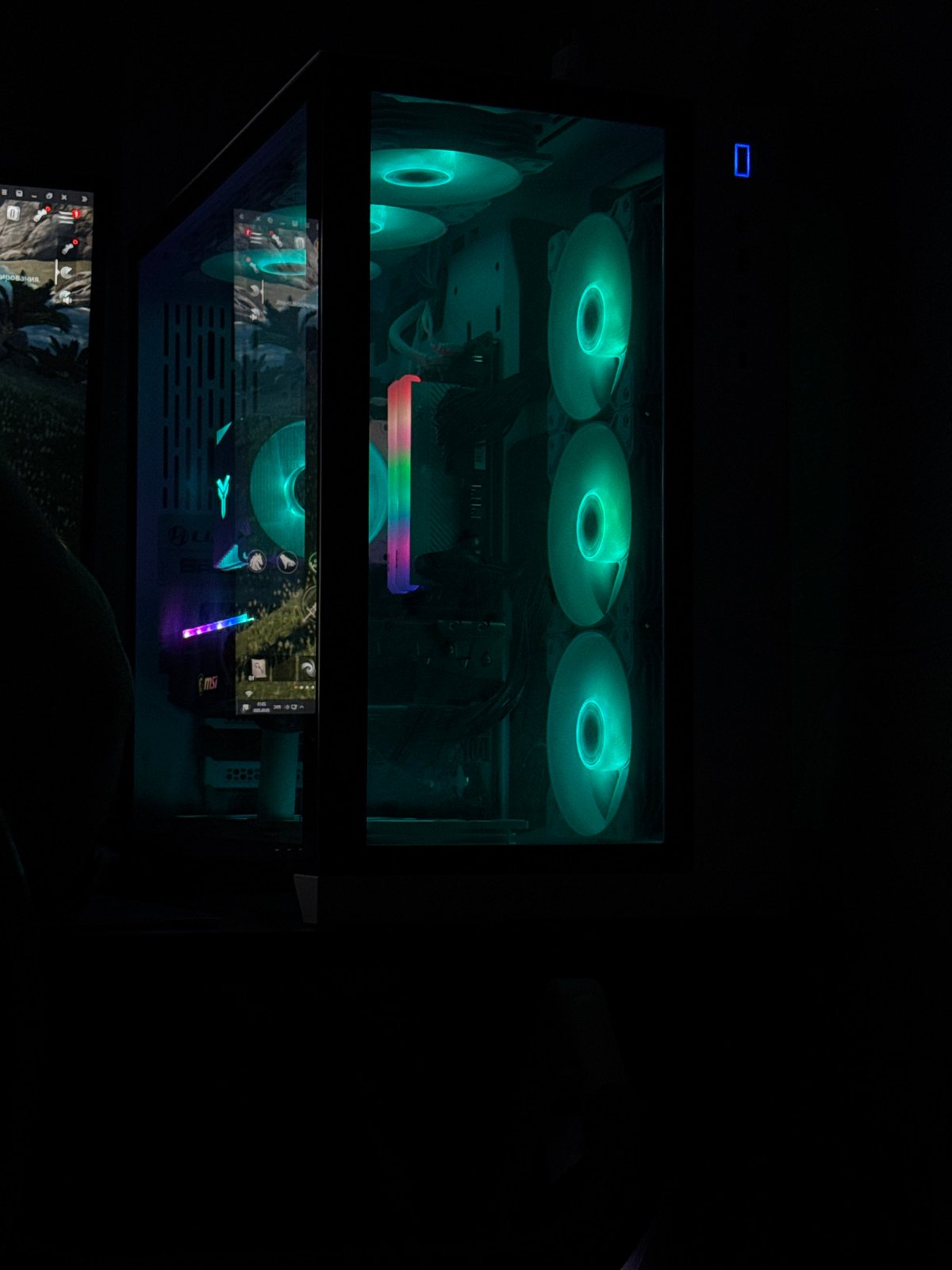 RGB gaming PC setup with a rainy street view outside