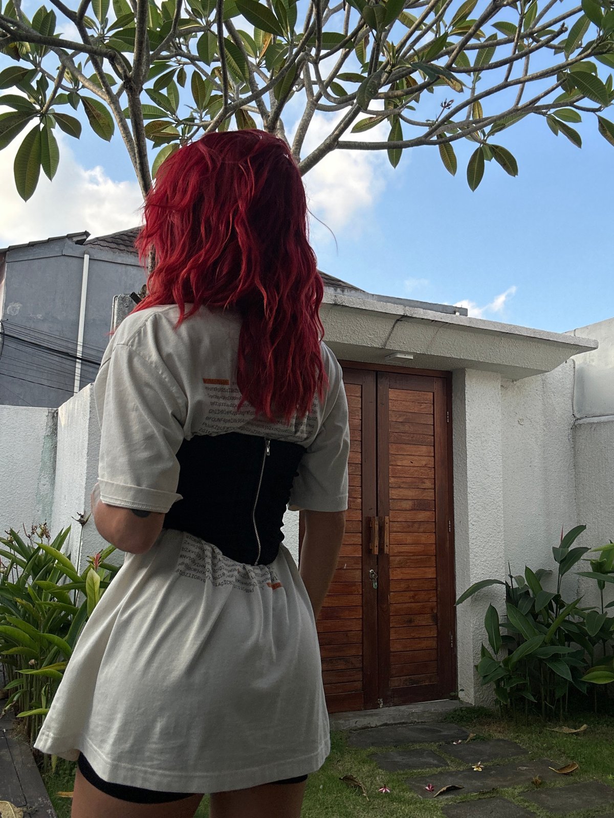 Red-haired person captured outdoors in North Kuta garden setting