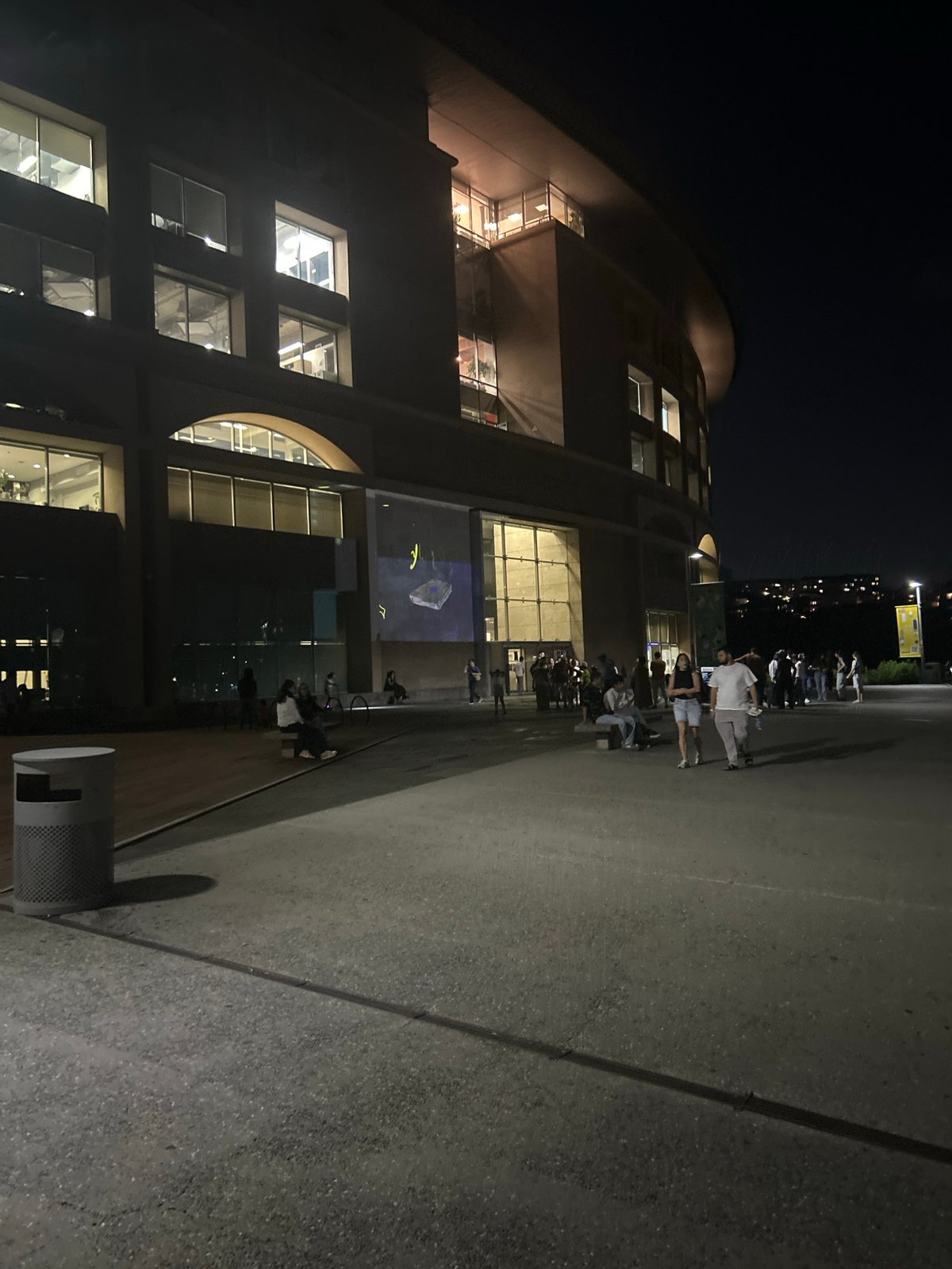 Evening gathering outside a large illuminated building in Yerevan