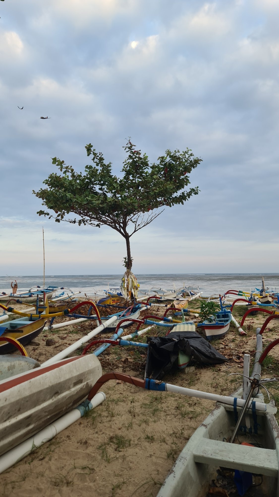 Bali beach scene blending fishing boats and surf gear