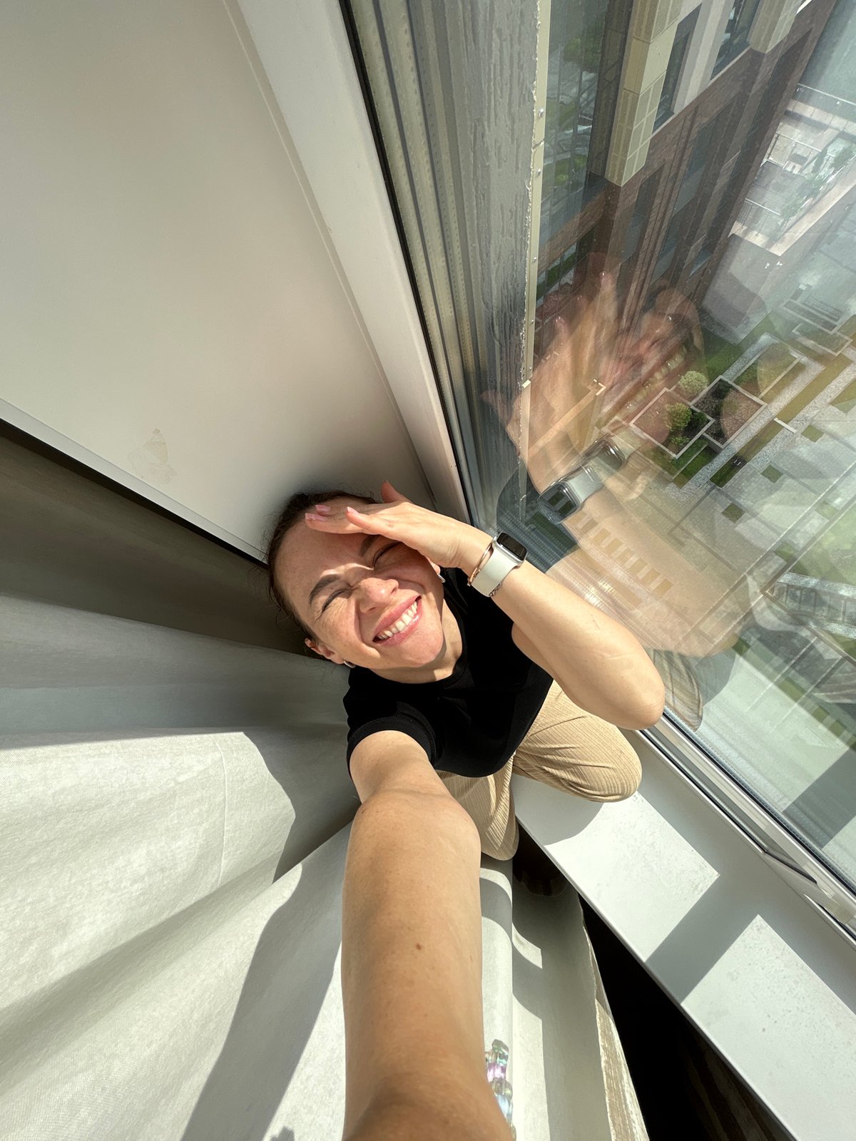 Woman takes playful window selfies in Yekaterinburg building