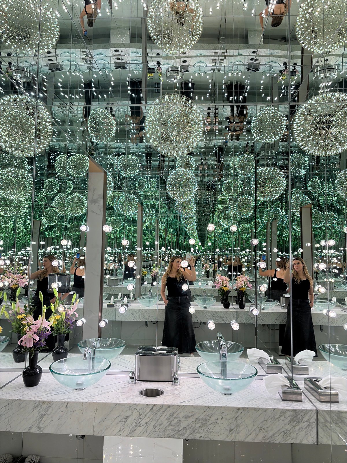 Woman takes selfies in infinity mirror bathroom