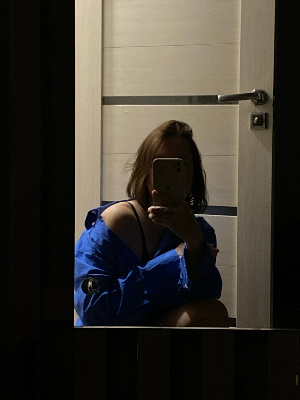 Woman takes mirror selfies in blue shirt, Chaikovsky Russia