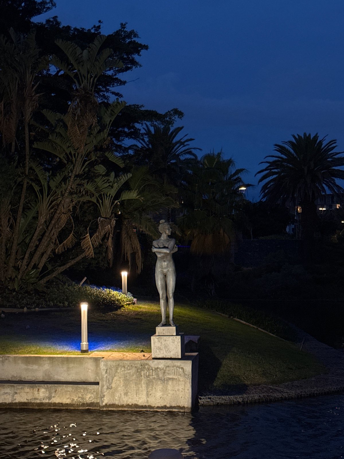 Illuminated nude statue observed near water in Milnerton