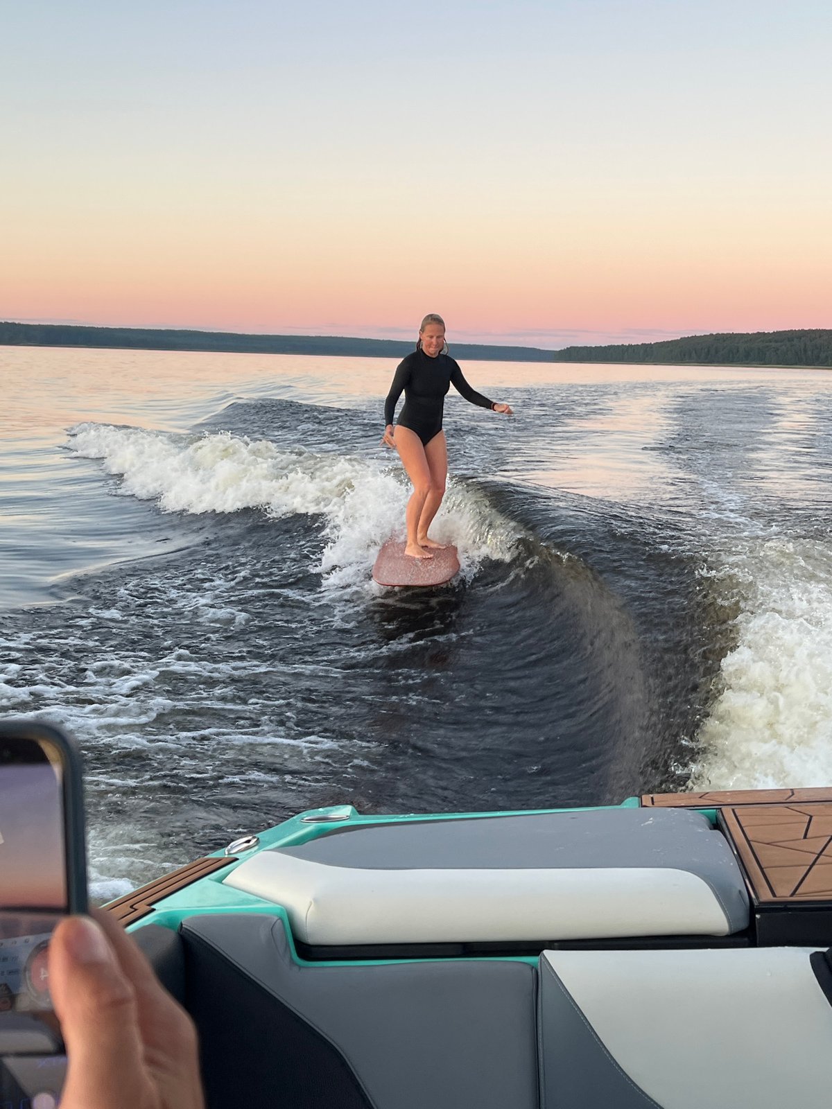 Wake surfing session on a Gromovo lake at sunset