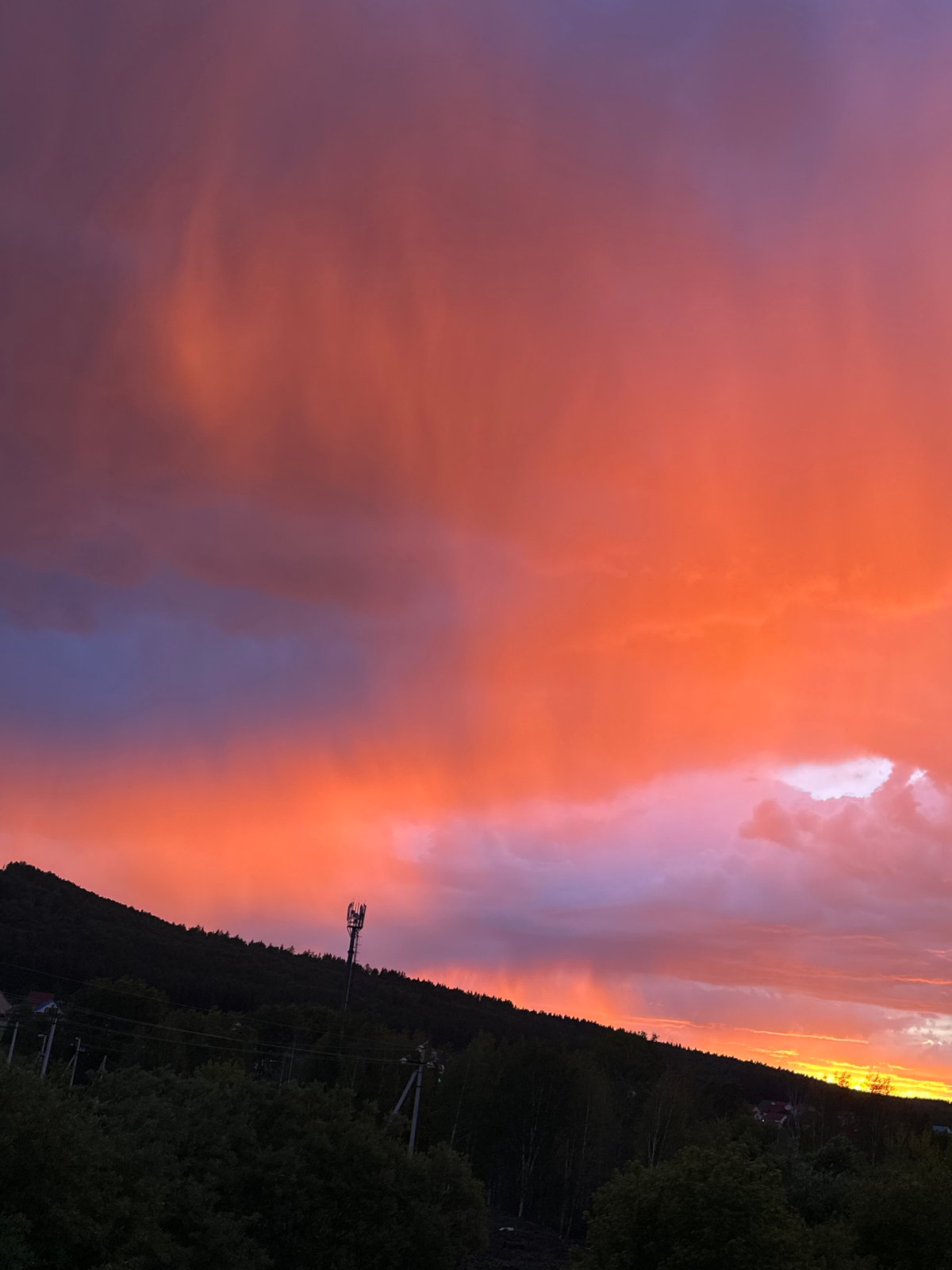 Dramatic sunset displays vibrant colors over rural landscape