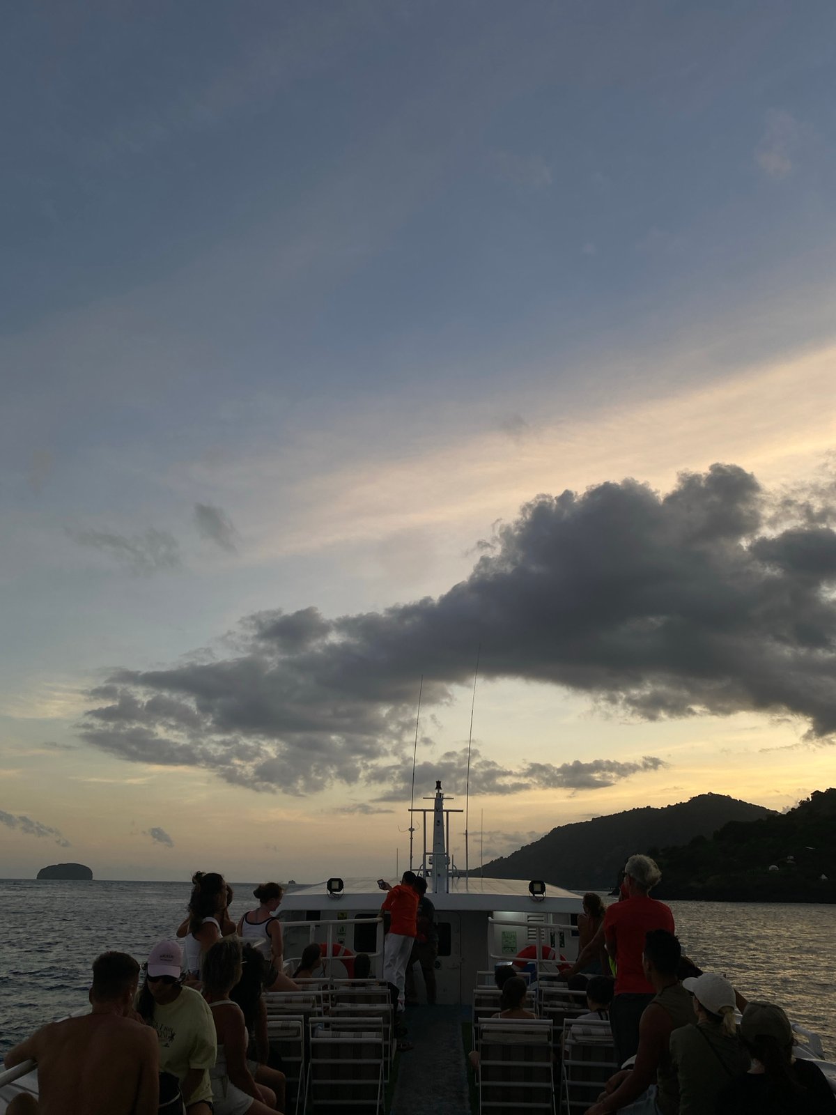 Boat passengers travel past rocky island near Karangasem Indonesia