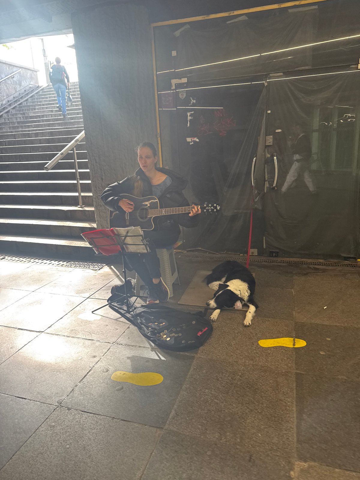Street musician performs with guitar near Sofia underground passage