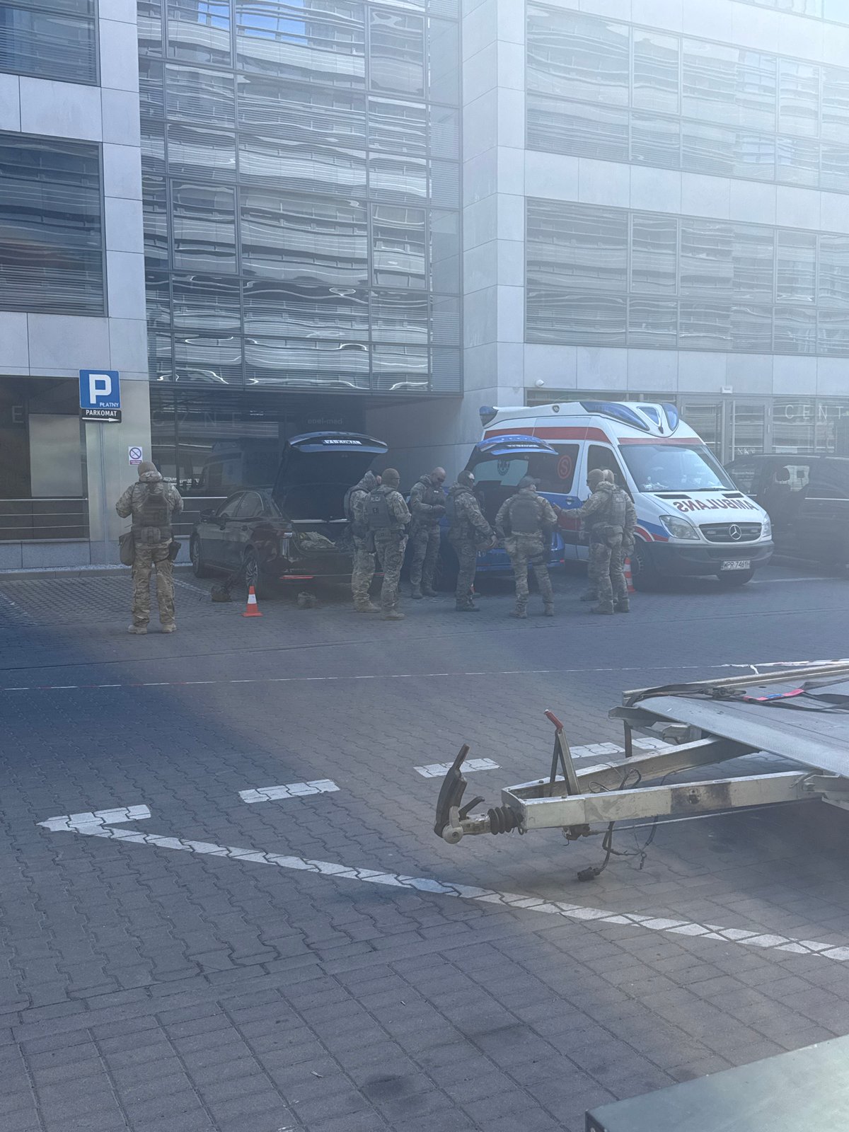 Military personnel gather around ambulance on Warsaw street