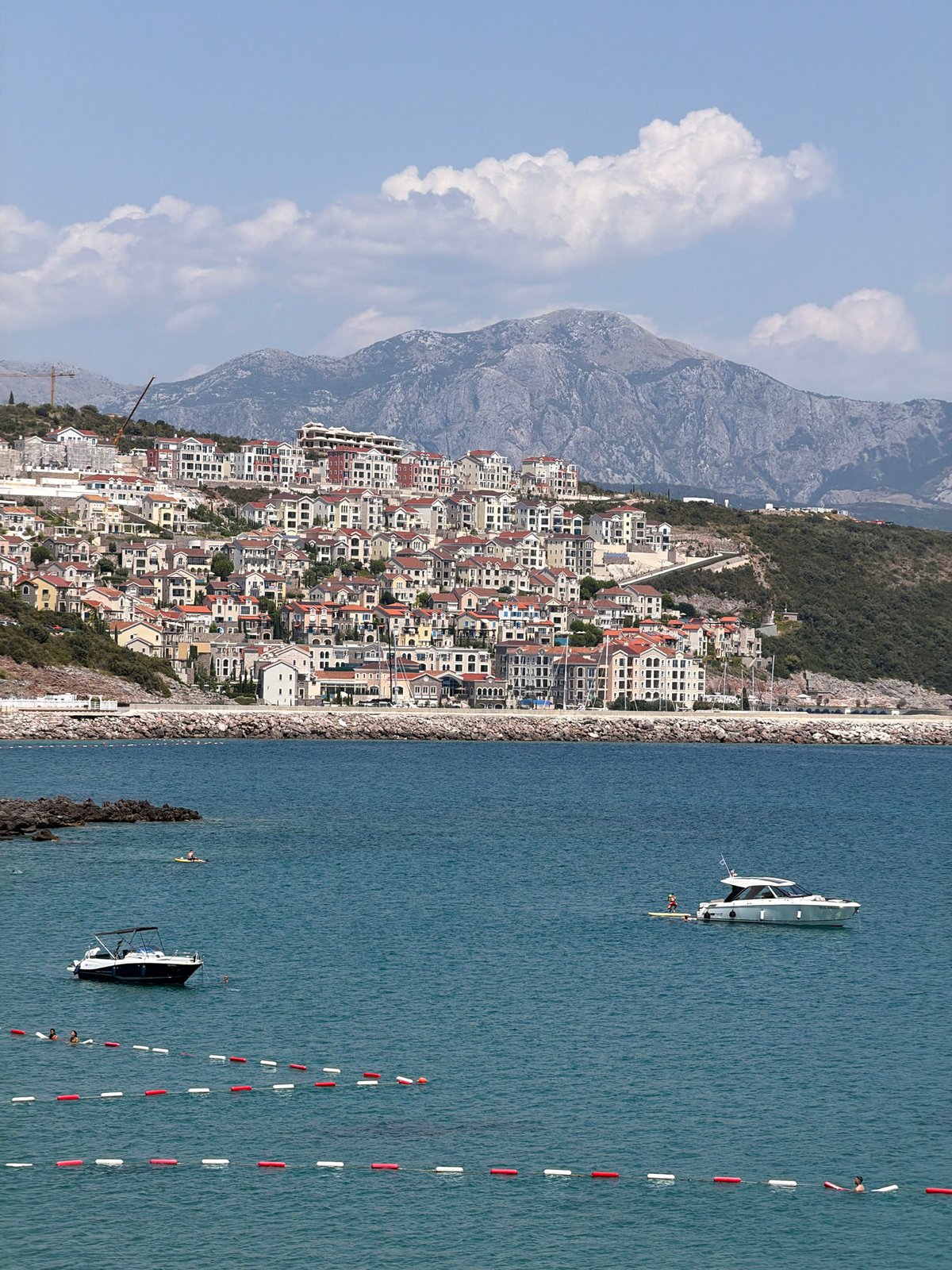 Gošići's hillside townscape and bay lighthouse on a clear summer day