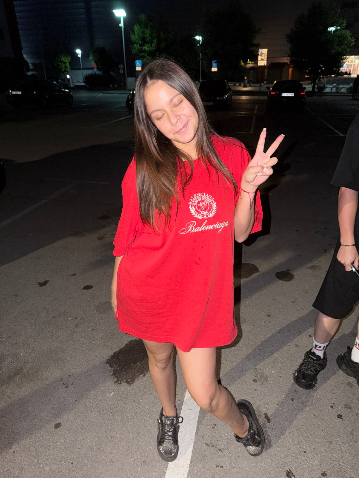Woman poses in parking lot during nighttime photo session
