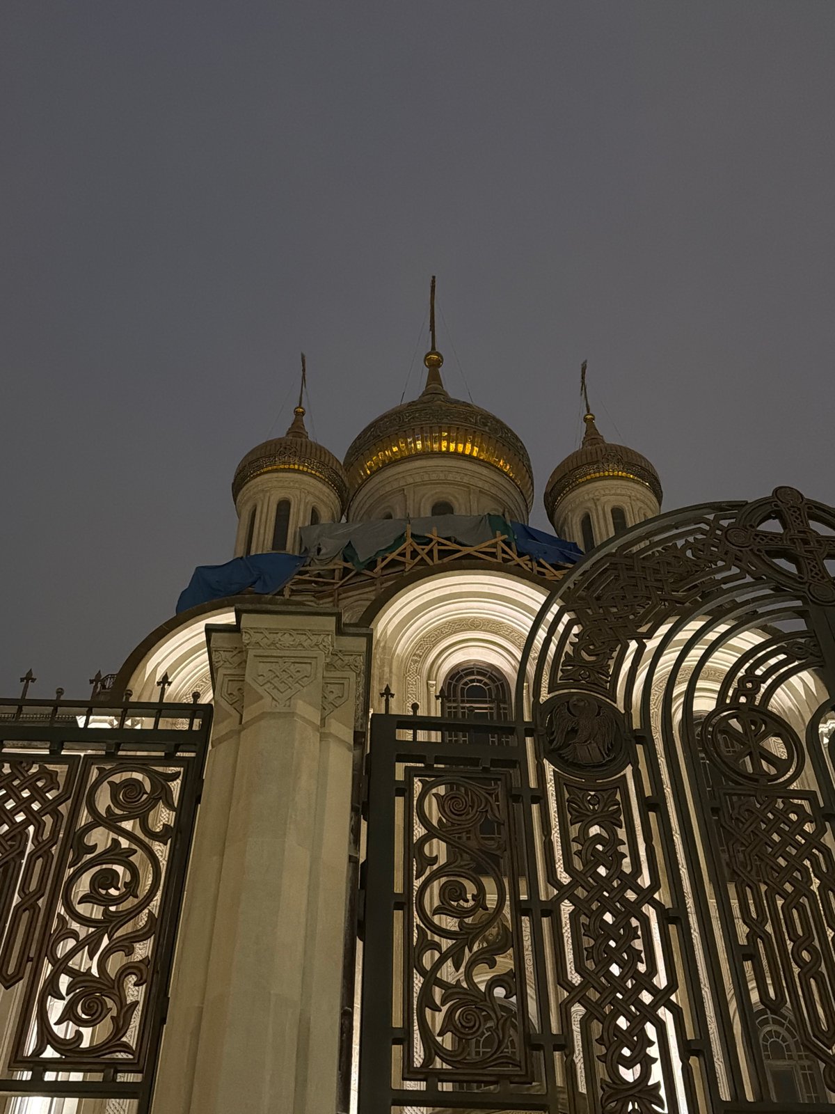 Orthodox church with golden domes illuminated at night in Moscow