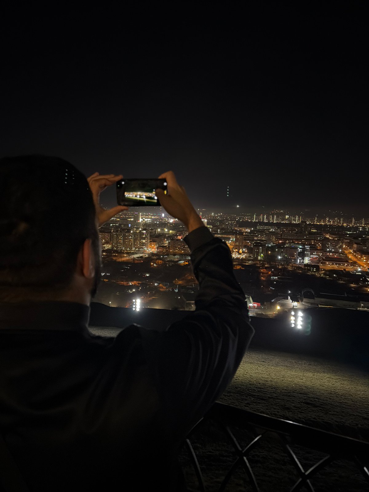 Tourist photographs Krasnoyarsk city skyline from observation deck