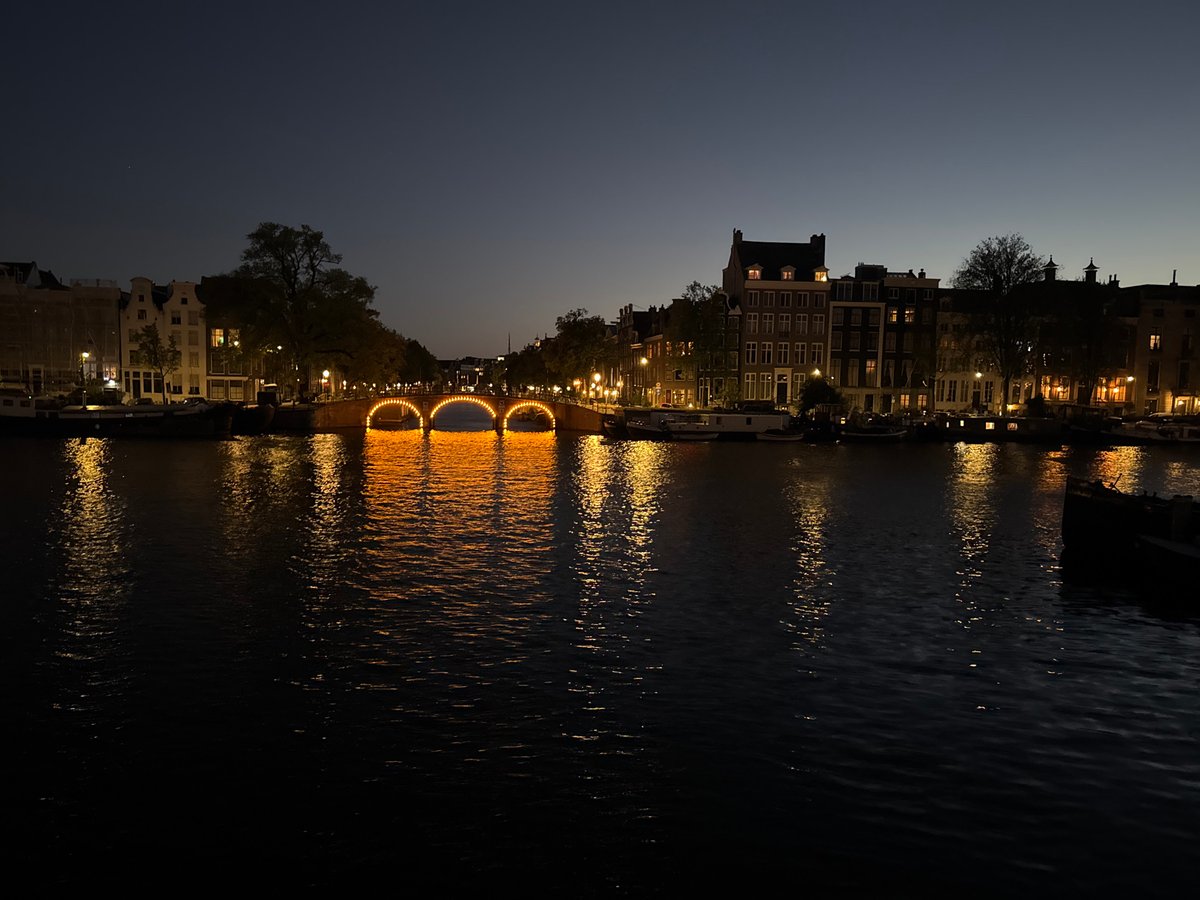 Amsterdam canals at dusk, bridges and a docked boat