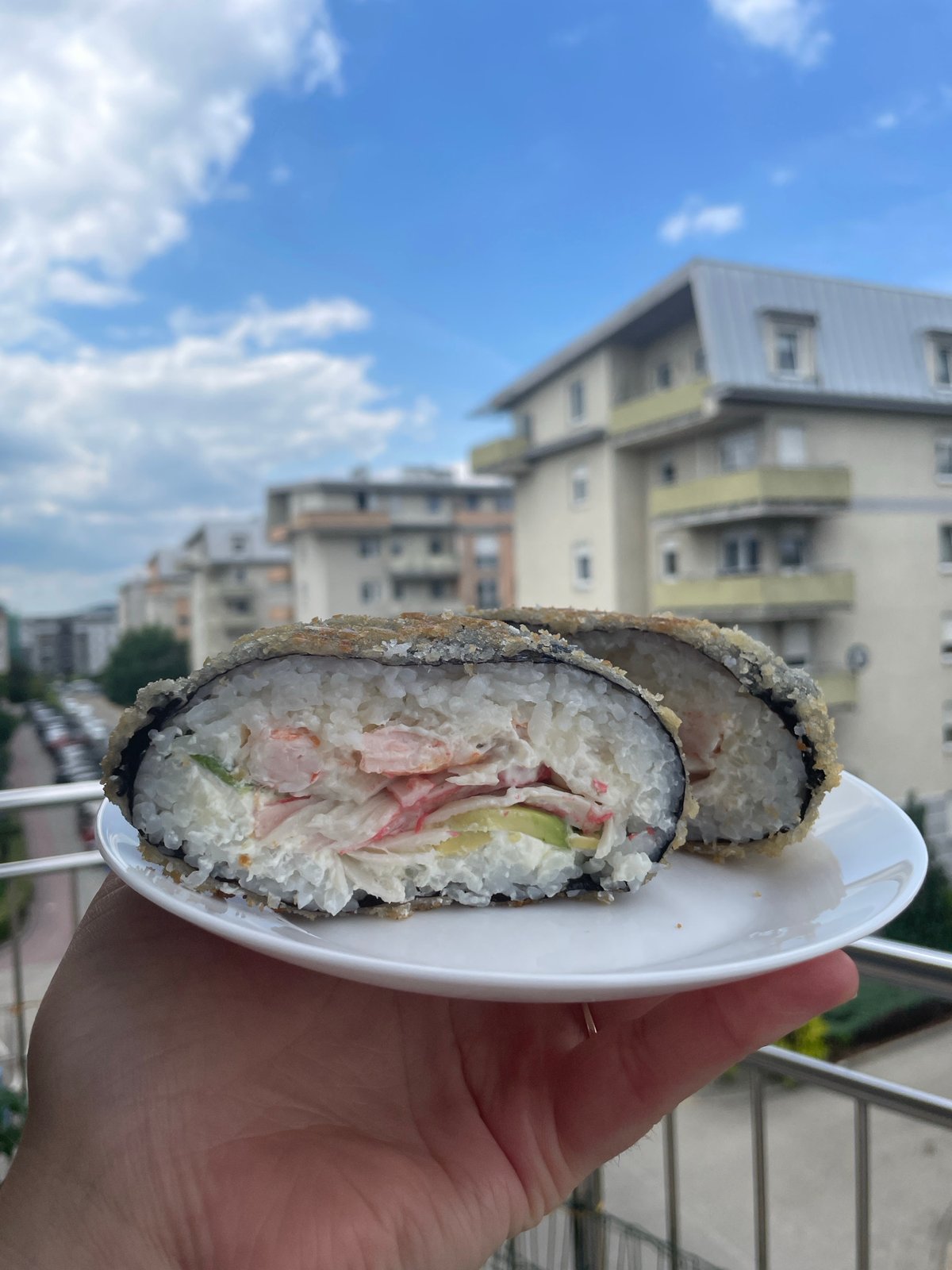 Outdoor lunch featuring deep-fried sushi rolls and beverages documented