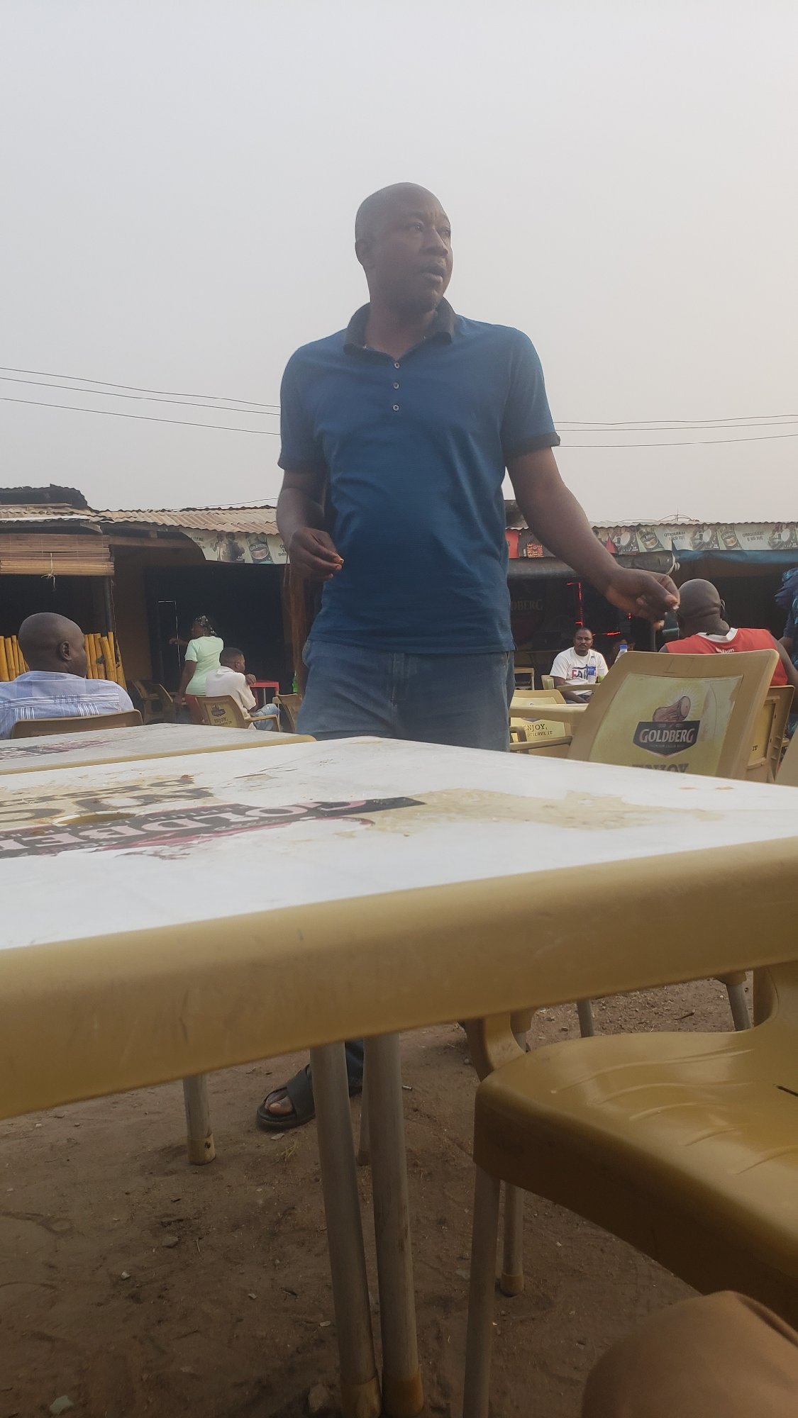 Woman cleans tables at outdoor establishment in Narayi Nigeria