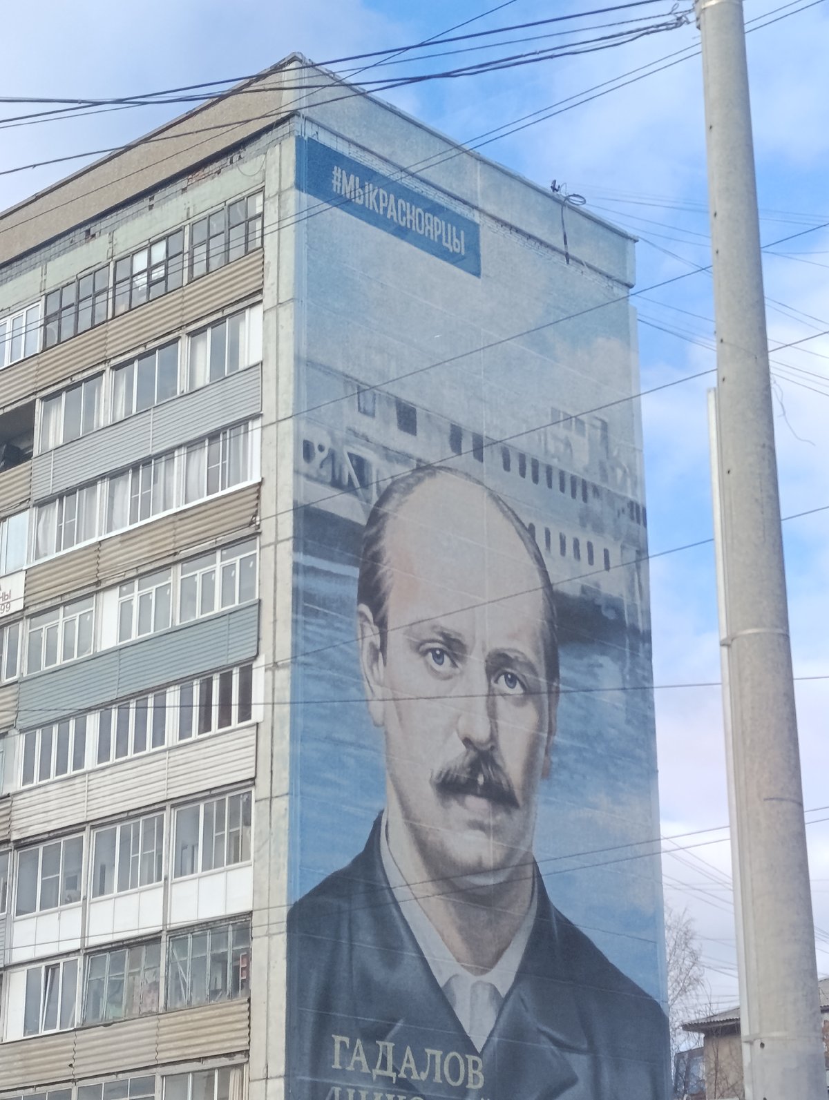 Large portrait mural documented on Krasnoyarsk apartment building