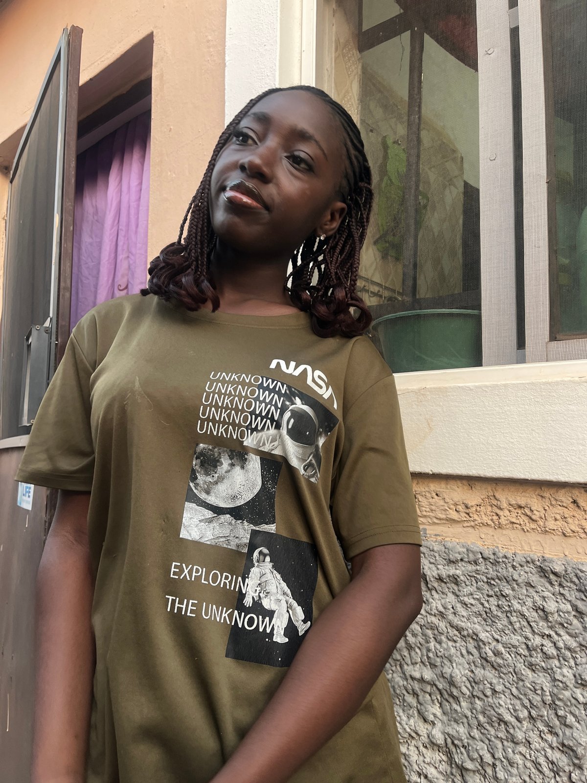 Woman in NASA shirt photographed around Abuja neighborhoods