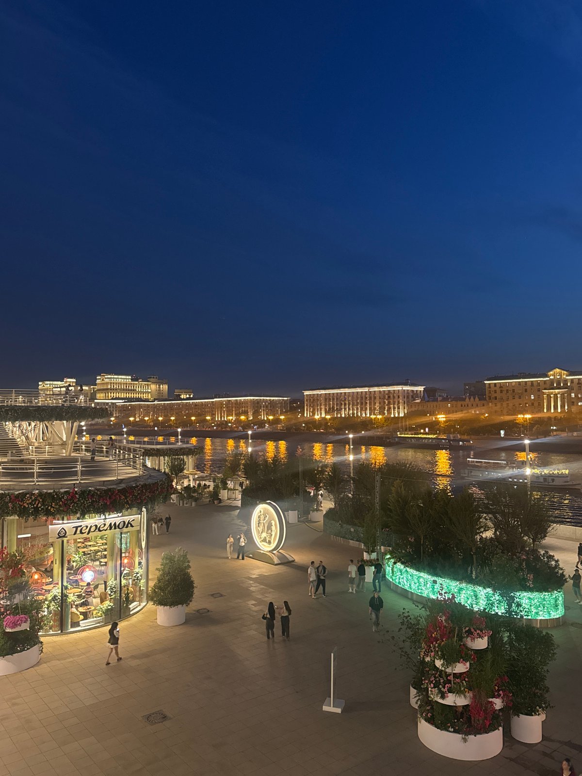 Evening stroll captured along Moscow's illuminated Luzhkov Bridge waterfront