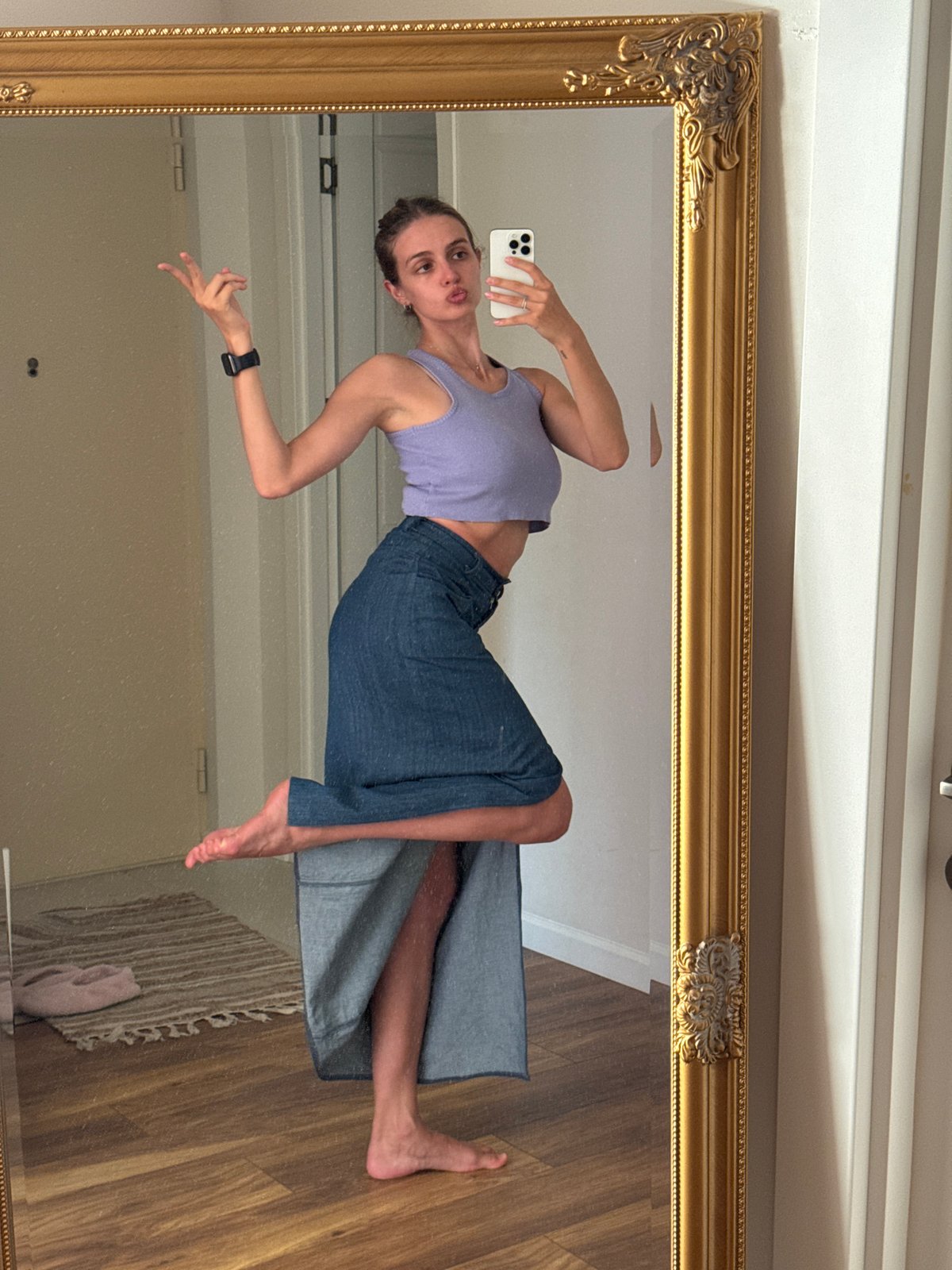 Woman takes mirror selfies indoors, urban hillside views captured