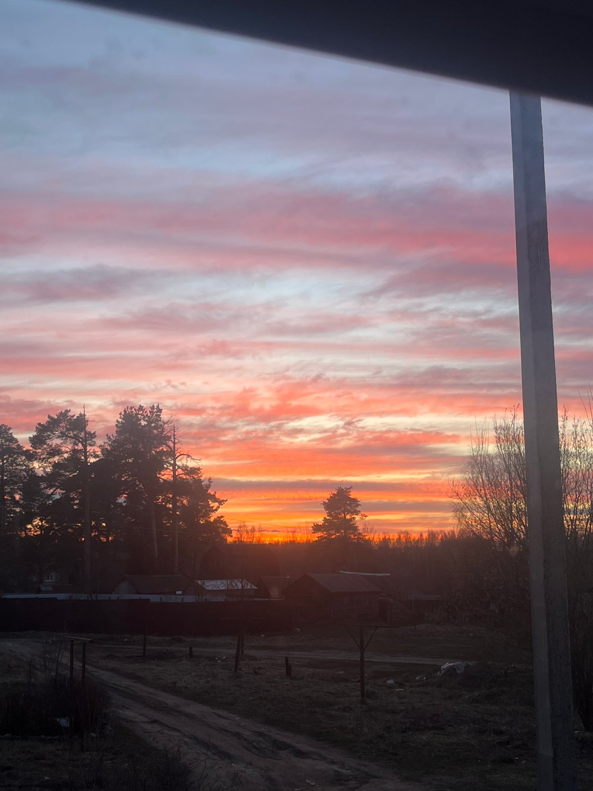 Resident documents colorful sunset in rural Russia village