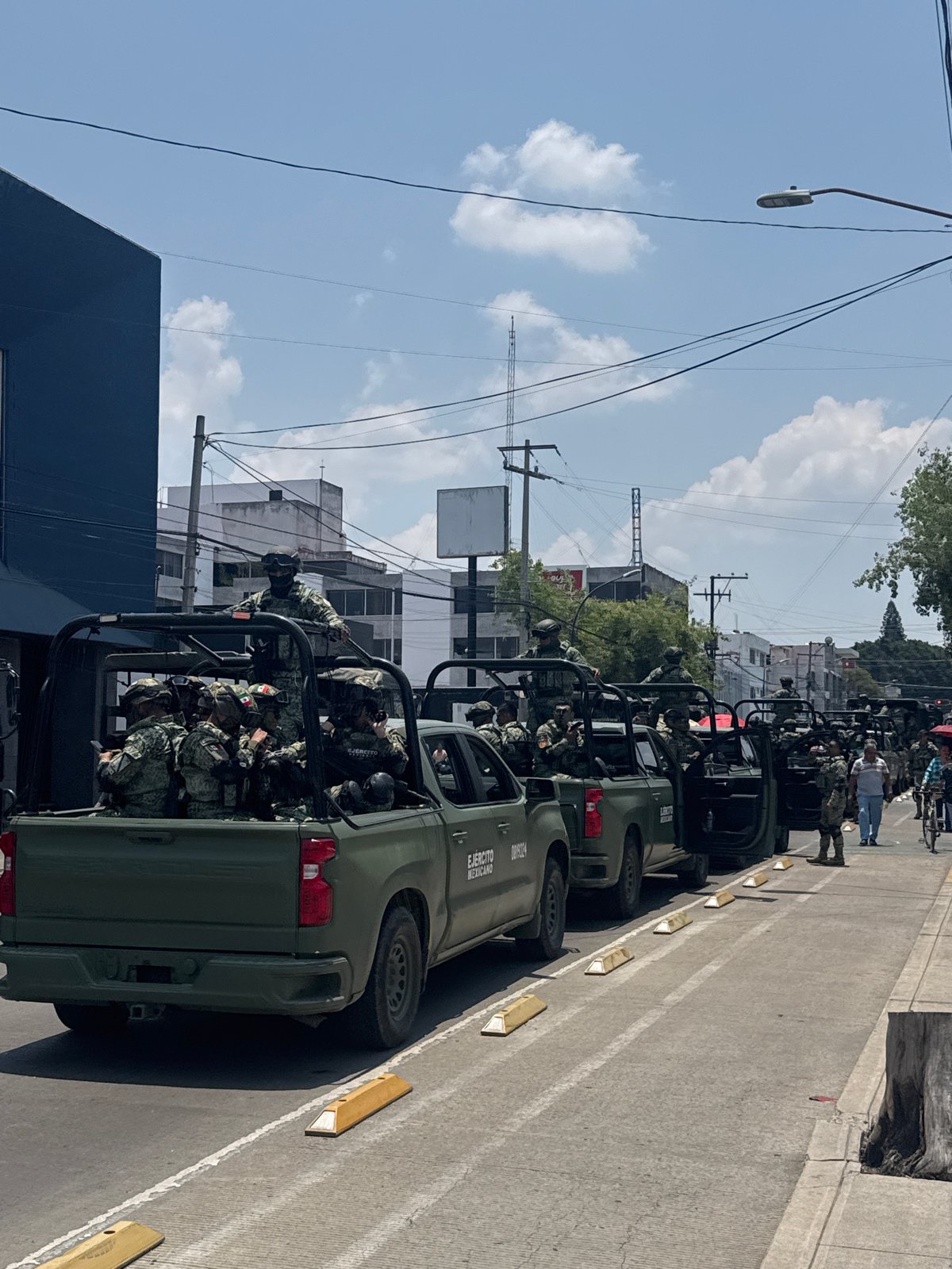 Military formation observed on Puebla street with vehicles, troops
