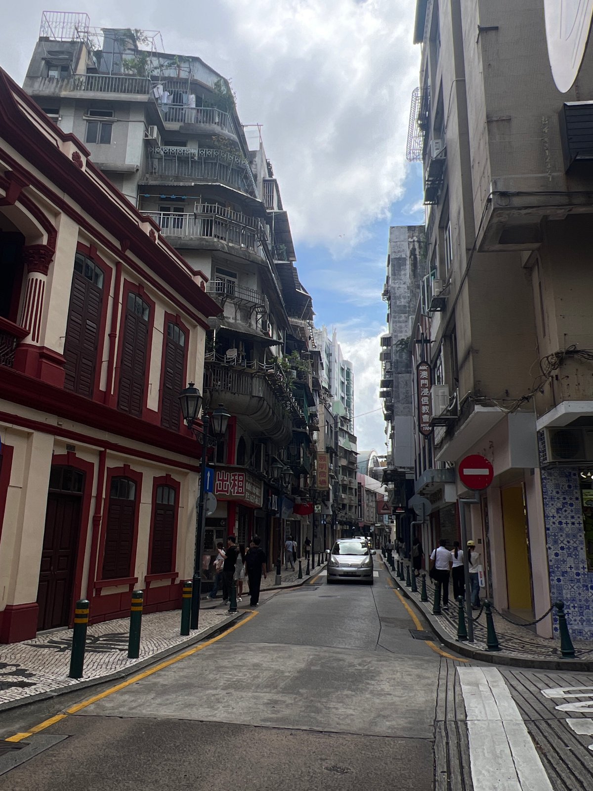 Tourists pose along historic cobblestone streets in Macau