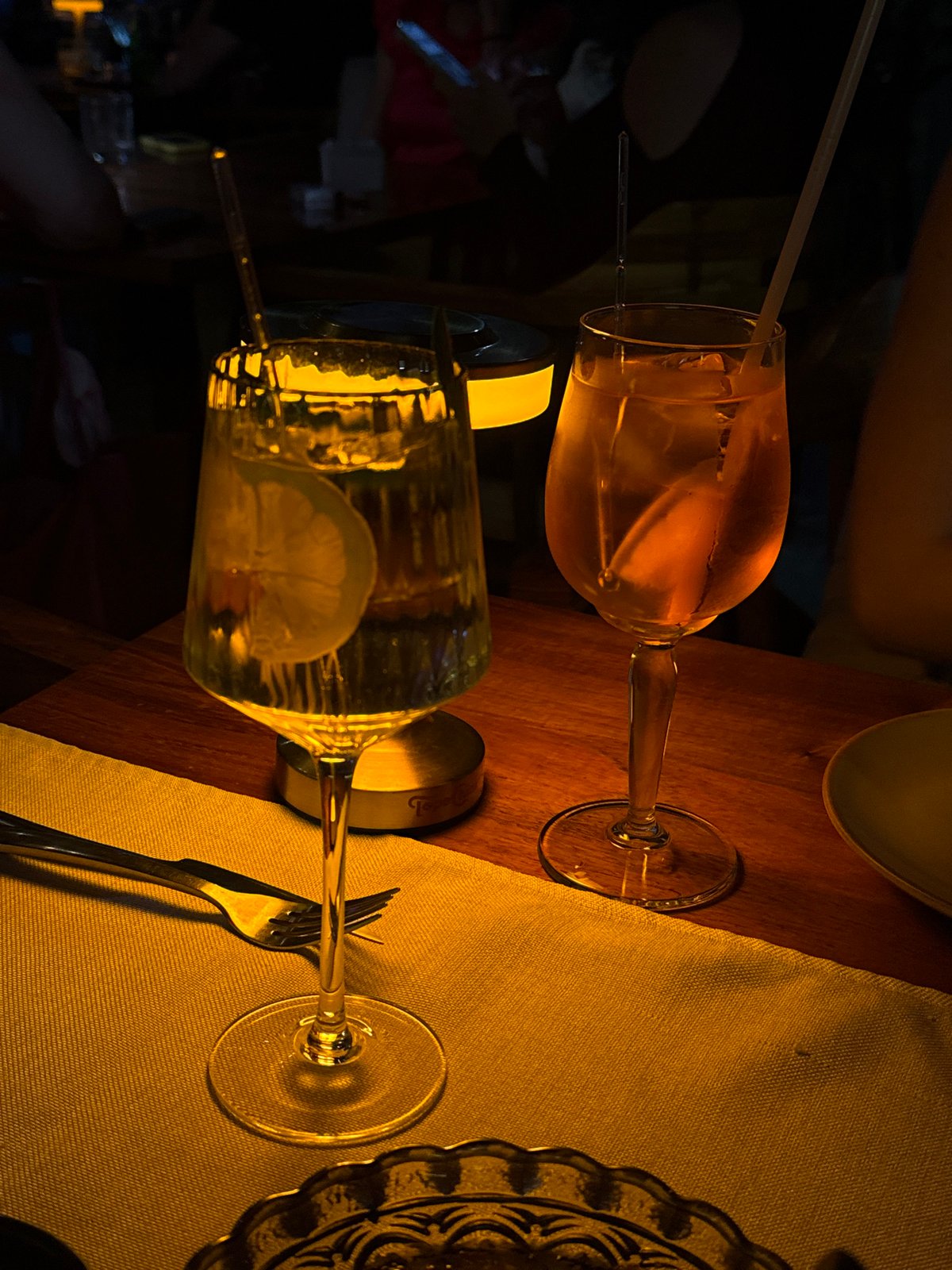 Stemmed glasses captured on wooden table in dimly lit establishment