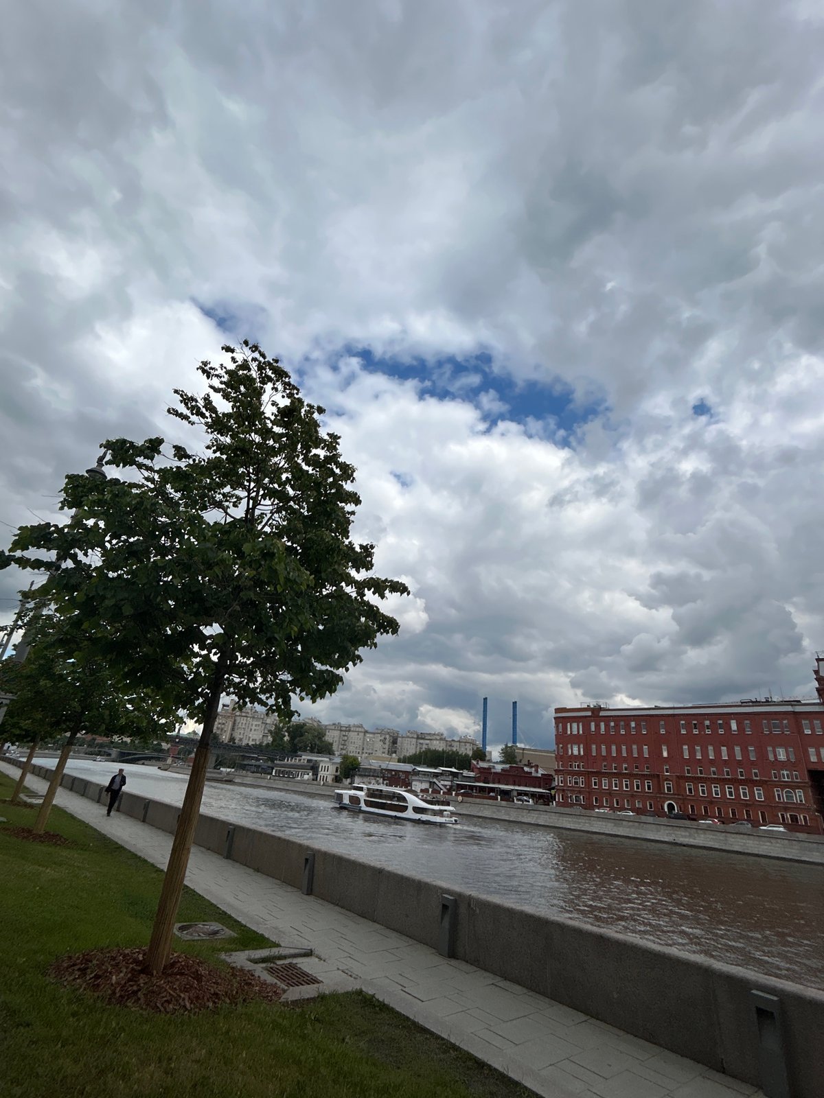 Morning life along Moscow's river embankment under cloudy skies