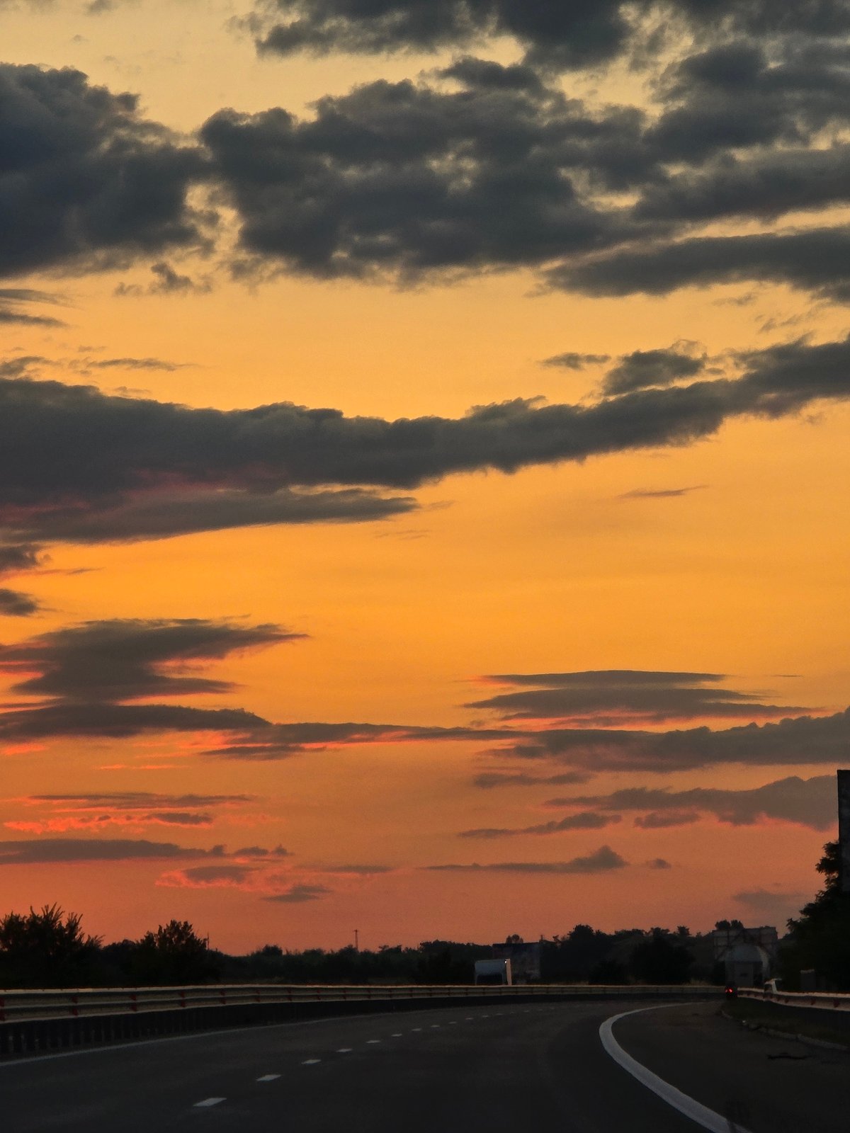 Bulgarian highway curves under a vivid sunset sky