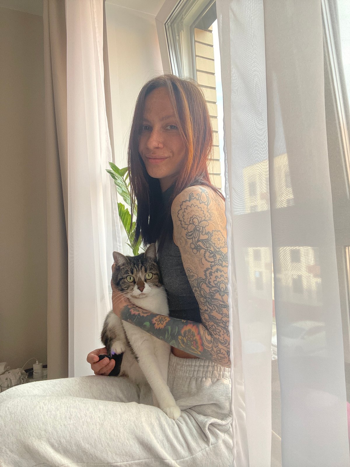 Tattooed woman photographed with tabby cat in Izhevsk home
