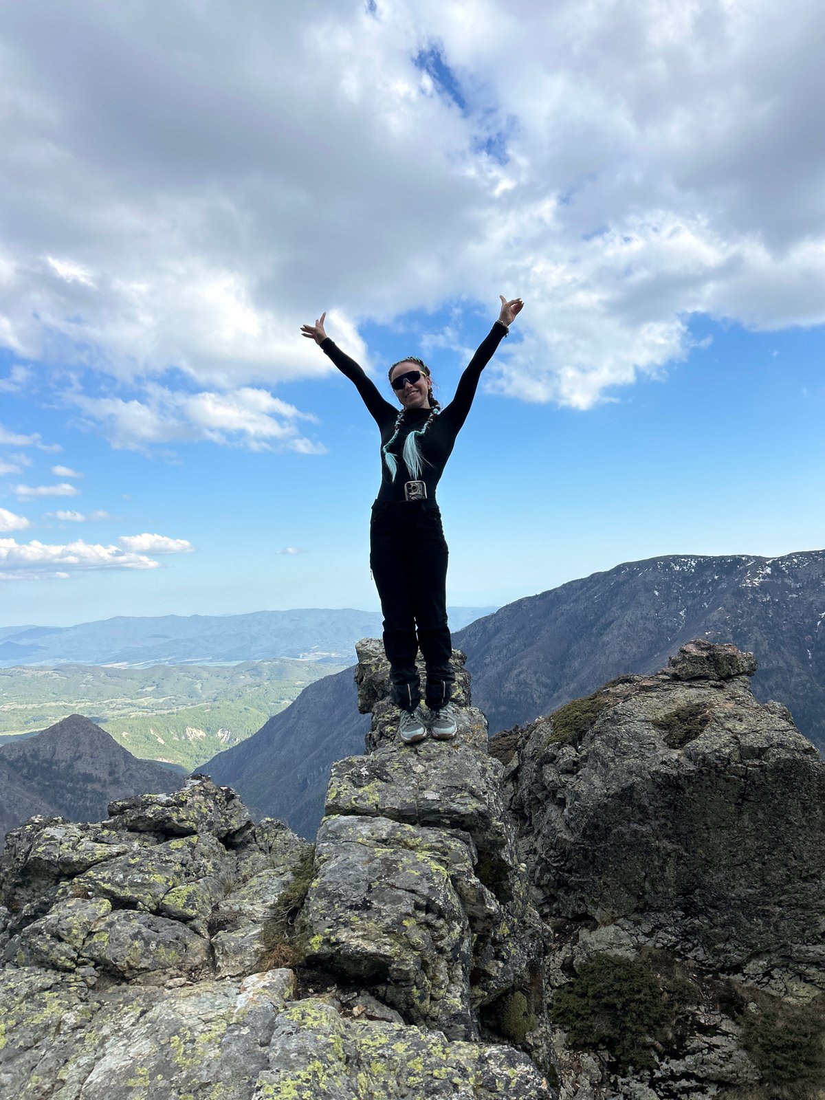 Person poses on mountain ledge in Kalofer, Bulgaria