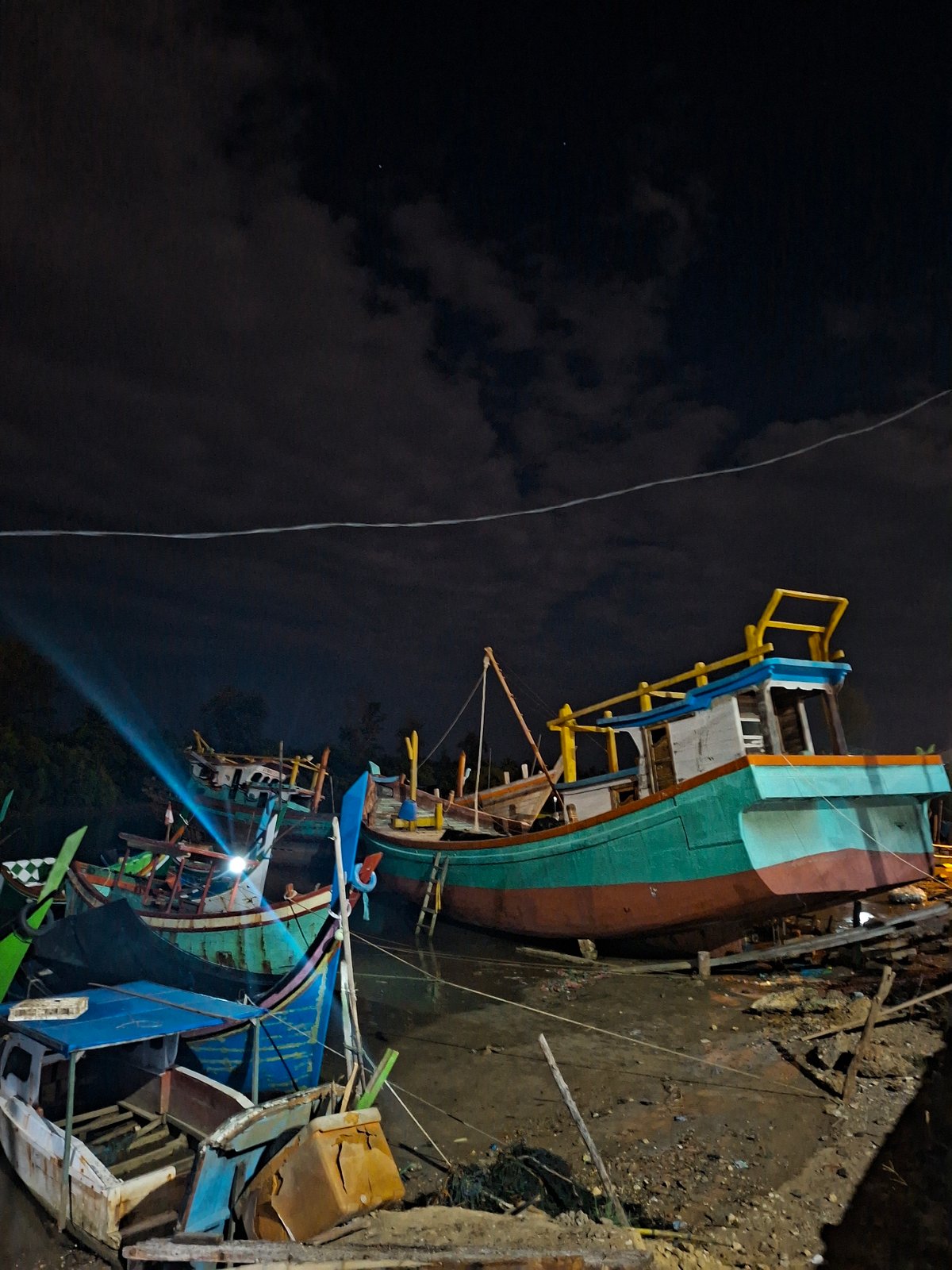 Colorful fishing boats clustered at Lhokseumawe boatyard captured at night