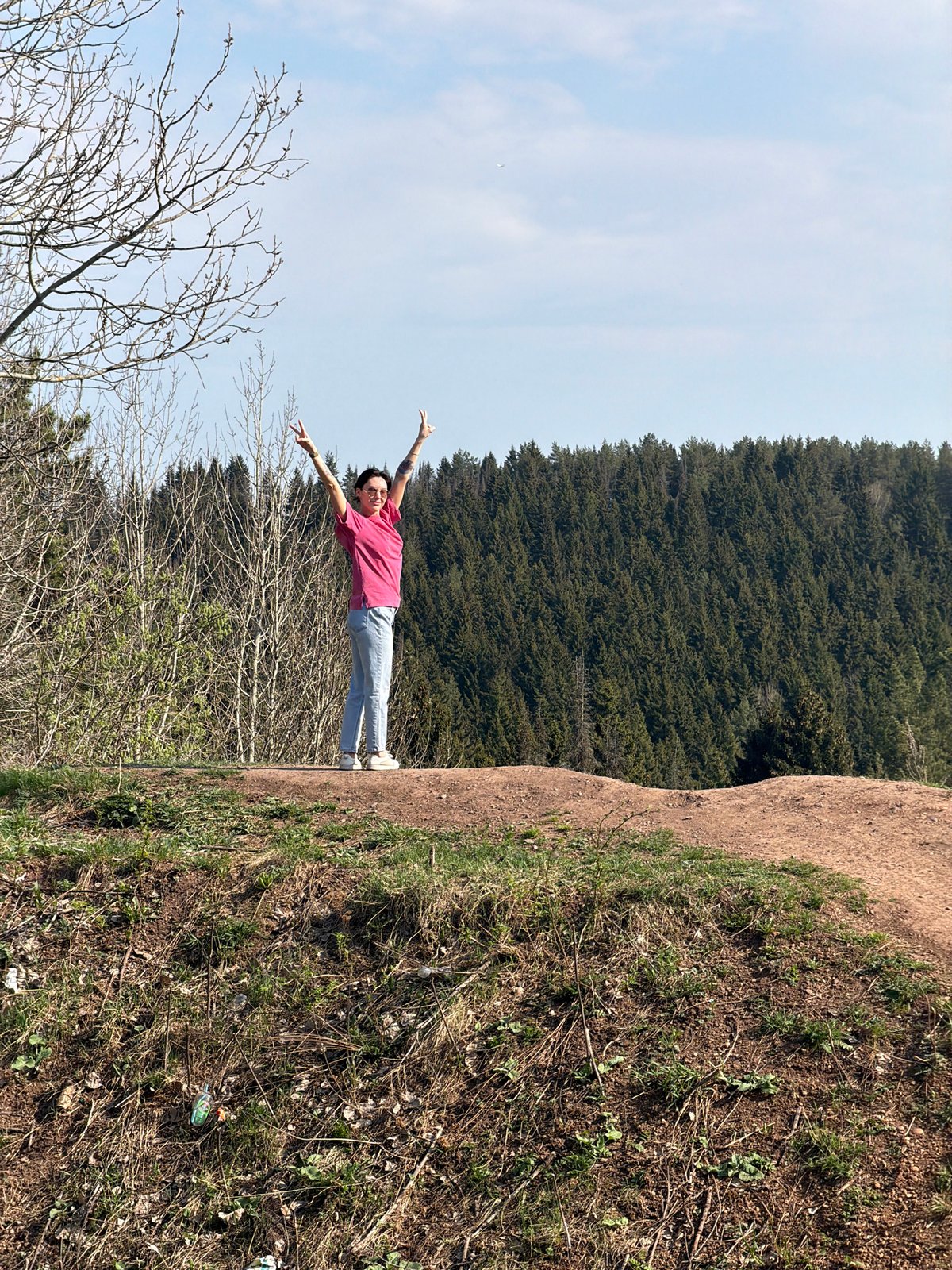 Person celebrates outdoors on Perm hillside during sunny spring day