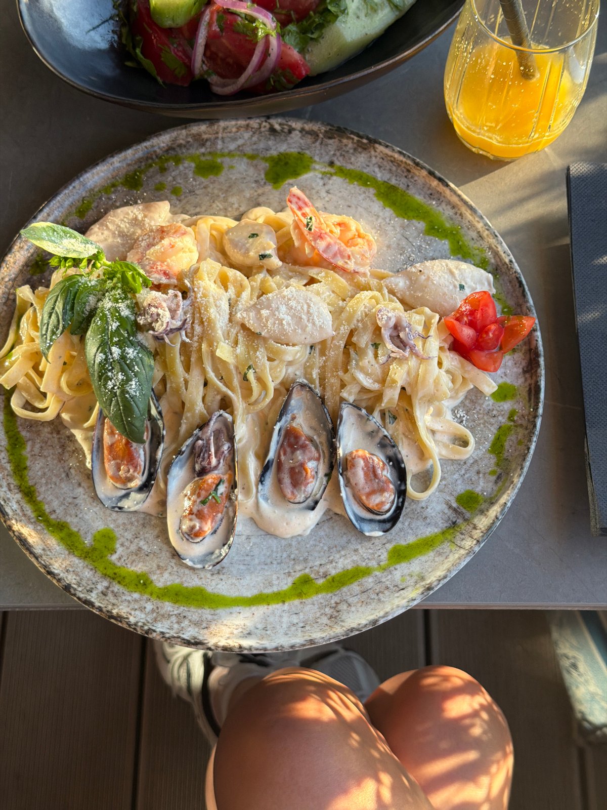 Woman enjoys seafood pasta at Montenegro coastal restaurant