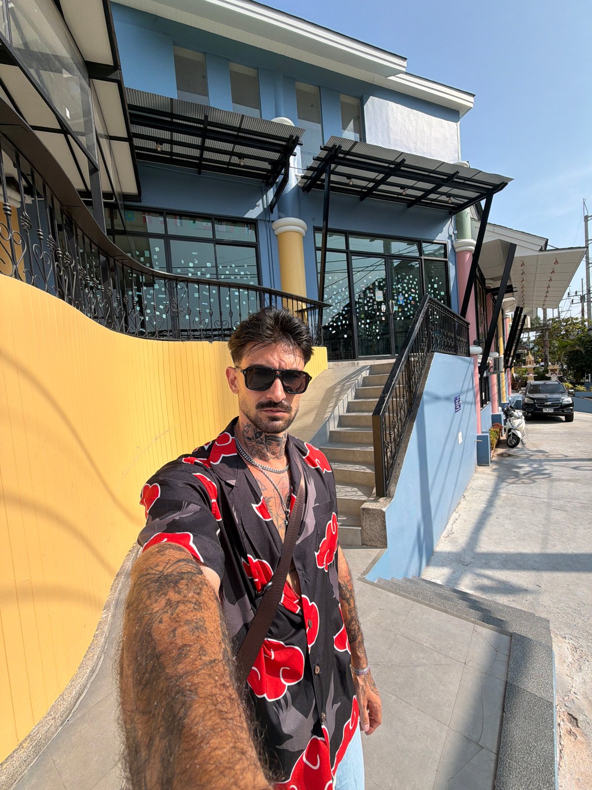 Tourist poses for photo at colorful Patong building complex