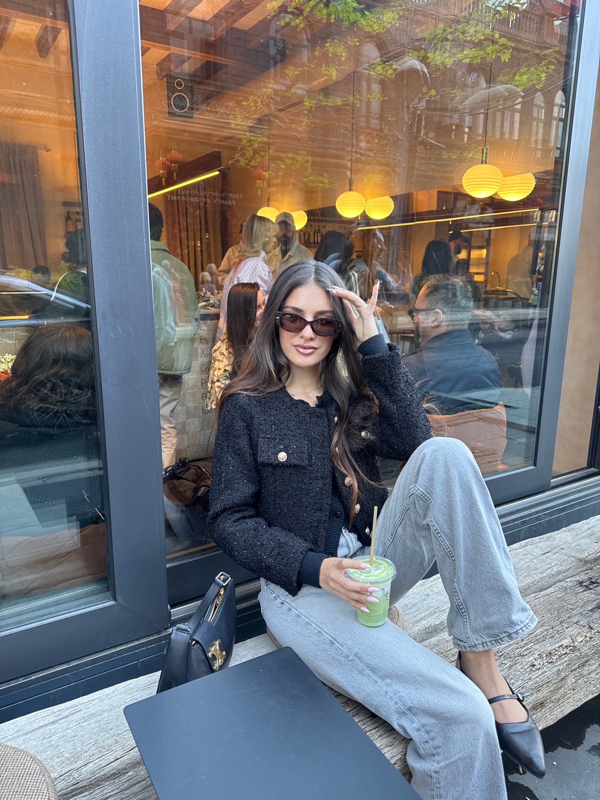 Woman enjoys matcha at Yerevan cafe amid pastry display