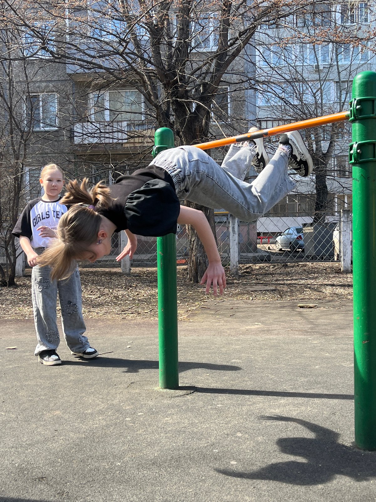 Girls play at sunny Krasnoyarsk playground during spring morning