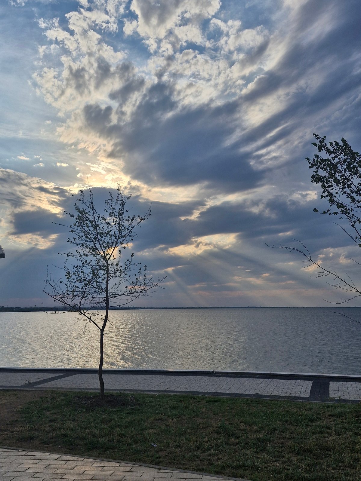 Golden hour at Kokshetau reservoir, clouds, sailboats, and lakeside calm