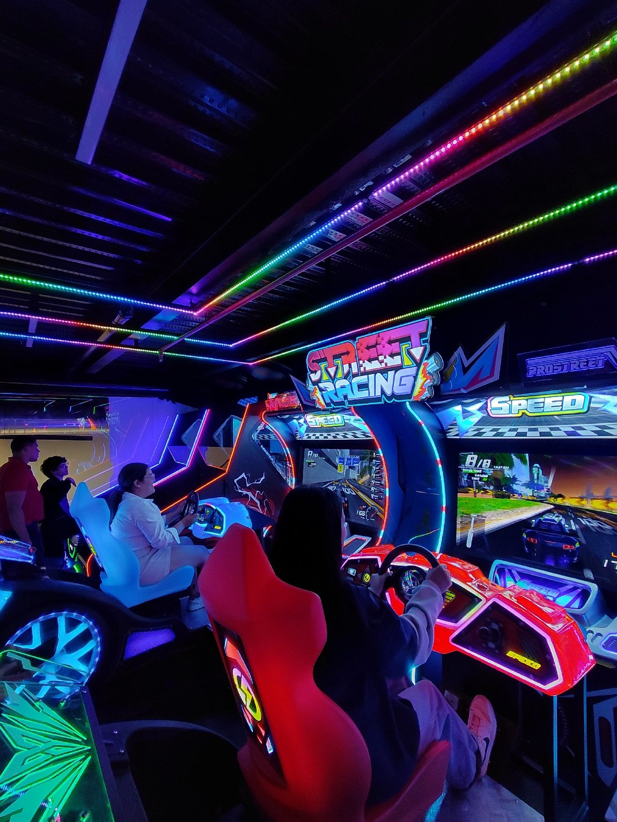 Neon-lit arcade gaming session in Pampatar, Venezuela