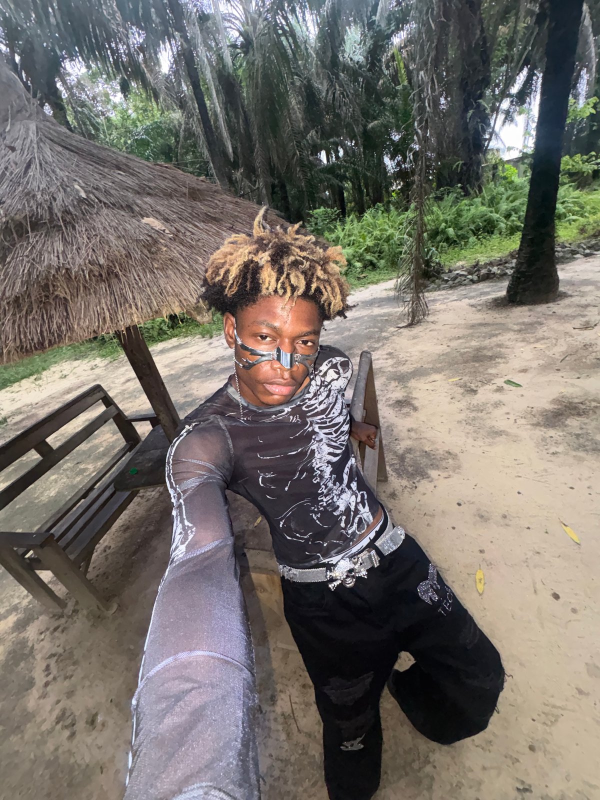 Person in skeleton-print clothing rests on bench in Sangotedo